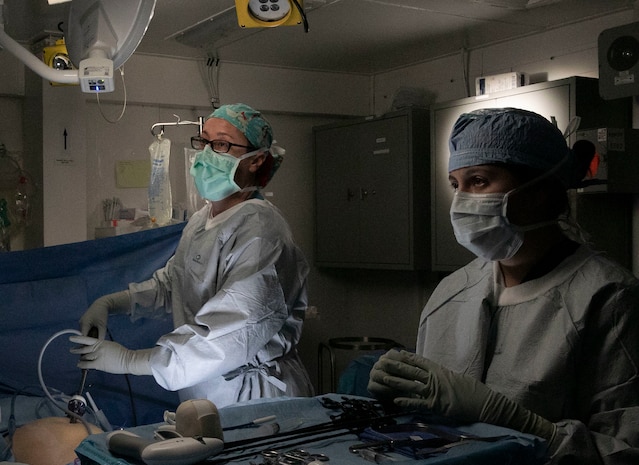 040622-N-EI119-1044 ATLANTIC OCEAN (Jun. 04, 2022) CDR Shalimar Andrews and Hospital Corpsman 3rd Class Cheyenne Taunah monitor a patient’s abdominal cavity while performing an appendectomy aboard the aircraft carrier USS George H. W. Bush (CVN 77) Jun. 04, 2022. The George H.W. Bush Carrier Strike Group (CSG) is underway completing a certification exercise to increase U.S. and allied interoperability and warfighting capability before a future deployment. The George H.W. Bush CSG is an integrated combat weapons system that delivers superior combat capability to deter, and if necessary, defeat America's adversaries in support of national security. Carrier Air Wing (CVW) 7 is the offensive air and strike component of CSG-10 and the George H.W. Bush CSG. The squadrons of CVW-7 are Strike Fighter Squadron (VFA) 143, VFA-103, VFA-86, VFA-136, Electronic Attack Squadron (VAQ) 140, Carrier Airborne Early Warning Squadron (VAW) 121, HSC-5, and Helicopter Maritime Strike Squadron (HSM) 46. (U.S. Navy photo by Mass Communication 3rd Class Ryan Hartman)