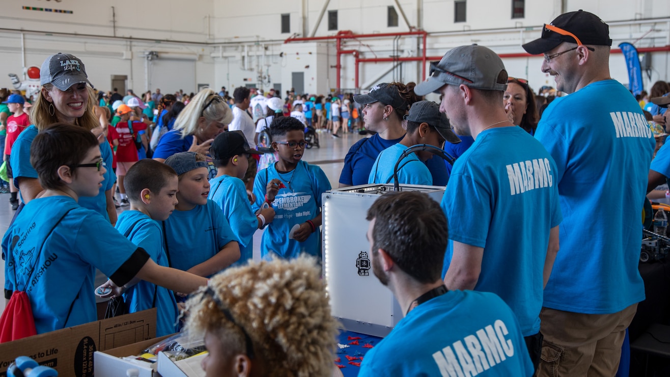 Mid-Atlantic Regional Maintenance Center’s Science, Technology, Engineering and Mathematics (STEM) volunteers explains the uses of 3D printing technology to students from Virginia Beach, Virginia, at a STEM exhibit during the annual Naval Air Station Oceana Air Show. (U.S. Navy photo by Danielle Lofton/Released)