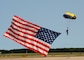 A member of the Leap Frog Team jumps with the American flag during the national anthem at the 2022 Naval Air Station (NAS) Oceana Air Show. The NAS Oceana Air Show's theme was "Back to the Beach", as it has been two years since the last performance.
