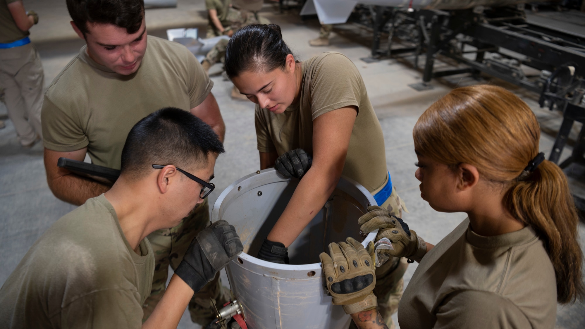 Four Munitions Systems specialists with the 332d Expeditionary Maintenance Squadron, Munitions Flight, assemble the tail section of an MK-84 conical bomb. These bombs are capable of penetrating up to 11 feet of concrete and spreading shrapnel in a 400 yard radius. (U.S. Air Force photo by: Tech. Sgt. Jeffery Foster)