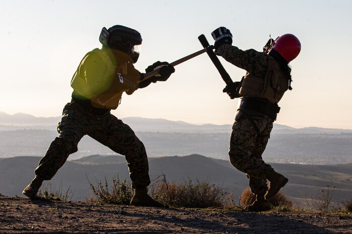 U.S. Marine Corps Sgt. Avery Luengo, left, a martial arts instructor trainer with 1st Battalion, 1st Marine Regiment, 1st Marine Division, and U.S. Marine Corps Cpl. Alexis Flippo, an imagery analysis specialist with 1st Intelligence Battalion, I Marine Expeditionary Force Information Group, conduct weapon-free sparring during a martial arts instructor course physical training session at Marine Corps Base Camp Pendleton, California, Dec. 8, 2022. MAI courses certify Marines to instruct and monitor Marine Corps Martial Arts Program training and advance Marines in the program, distinguishing their levels of experience with different colored belts.