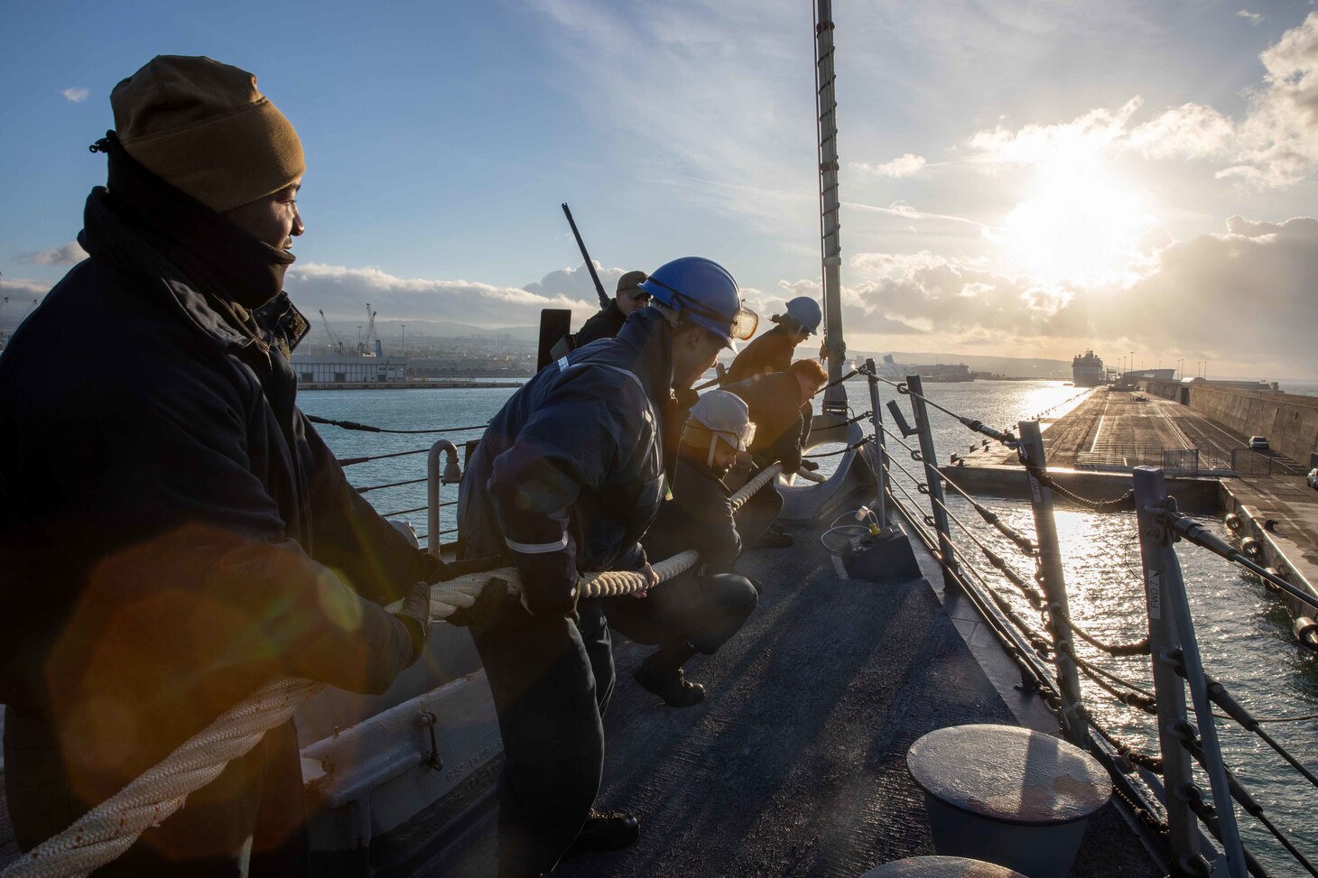 (Dec. 29, 2022) Sailors assigned to the Arleigh Burke-class guided-missile destroyer USS Nitze (DDG 94) heave line as the ship arrives in Civitavecchia, Italy for a scheduled port visit, Dec. 29, 2022. The George H.W. Bush Carrier Strike Group is on a scheduled deployment in the U.S. Naval Forces Europe area of operations, employed by U.S. Sixth Fleet to defend U.S., allied, and partner interests.