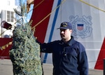 Petty Officer 2nd Class Benjamin Slappey of Coast Guard Cutter Mackinaw (WLBB 30) prepares to present a symbolic Christmas tree at Chicago's Navy Pier during the 23rd annual Christmas Ship ceremony Dec. 3, 2022.