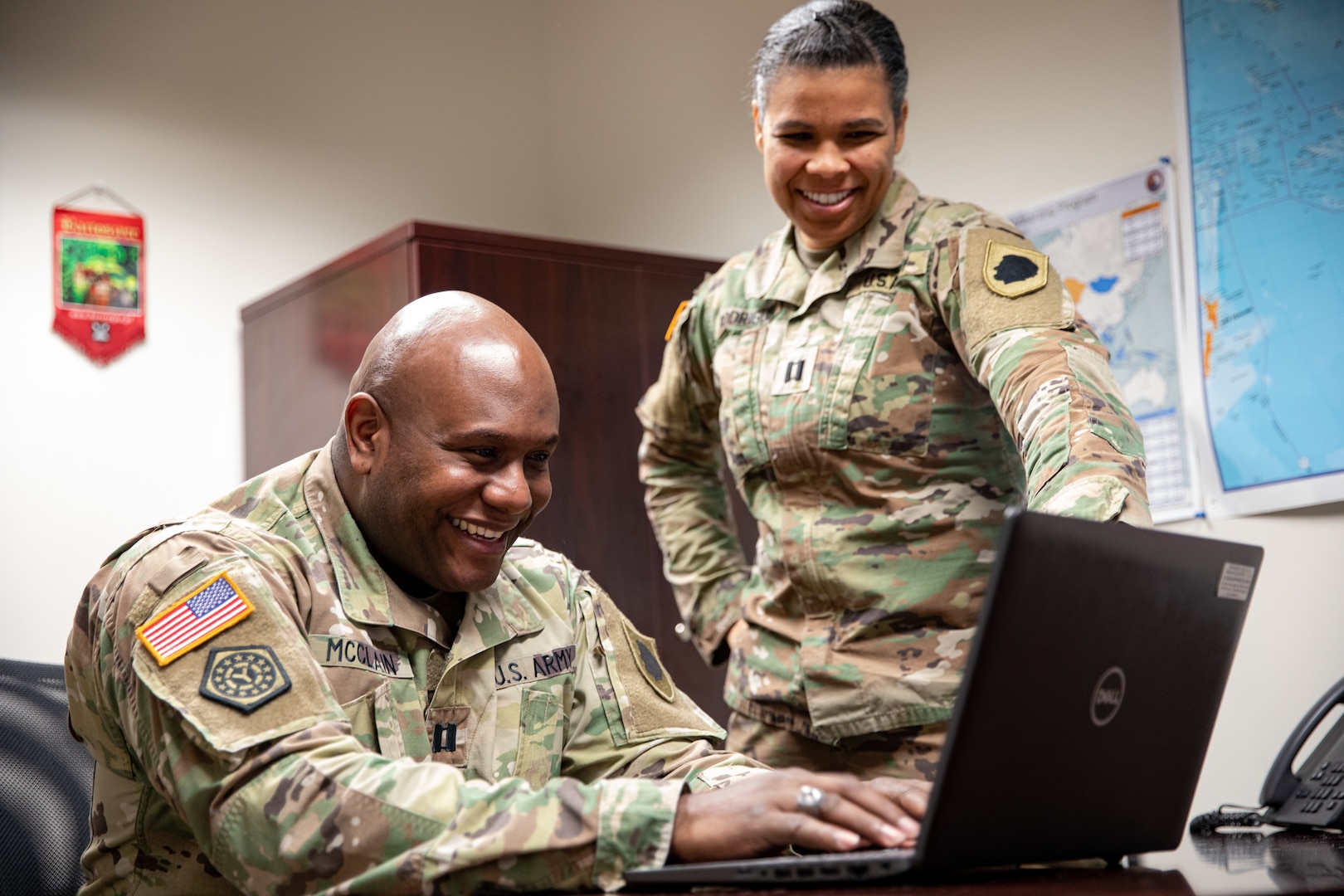Capt. Anthony McClain, the Illinois National Guard Director of Diversity and Inclusion, chats with Capt. Crystal Rodrigues, the State Partnership Program Director and International Affairs Officer, in their office at the Illinois National Guard Joint Force Headquarters on Camp Lincoln in Springfield, Ill Dec. 29, 2022. (U.S. Army photo by Sgt. Trenton Fouche, Joint Force Headquarters - Illinois National Guard)