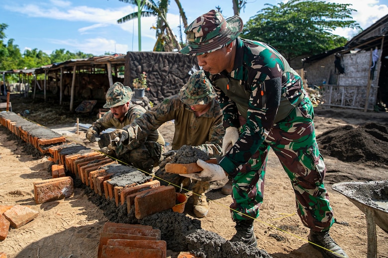 SUMBERWARU, INDONESIA (Dec. 15, 2022) - U.S. Marines with 13th Marine Expeditionary Unit, lay bricks with an Indonesian Korps Marinir (KORMAR) during an Engineering Civic Assistance Project (ENCAP) during Cooperation Afloat Readiness and Training/ Marine Exercise (MAREX), Dec. 15, 2022.  CARAT/MAREX Indonesia is a bilateral exercise between Indonesia and the United States designed to promote regional security cooperation, maintain and strengthen maritime partnerships, and enhance maritime interoperability. In its 28th year, the CARAT series is comprised of multinational exercises, designed to enhance U.S. and partner navies’ and marine corps abilities to operate together in response to traditional and non-traditional maritime security challenges in the Indo-Pacific region (U.S. Marine Corps photo by Sgt. Brendan Custer)