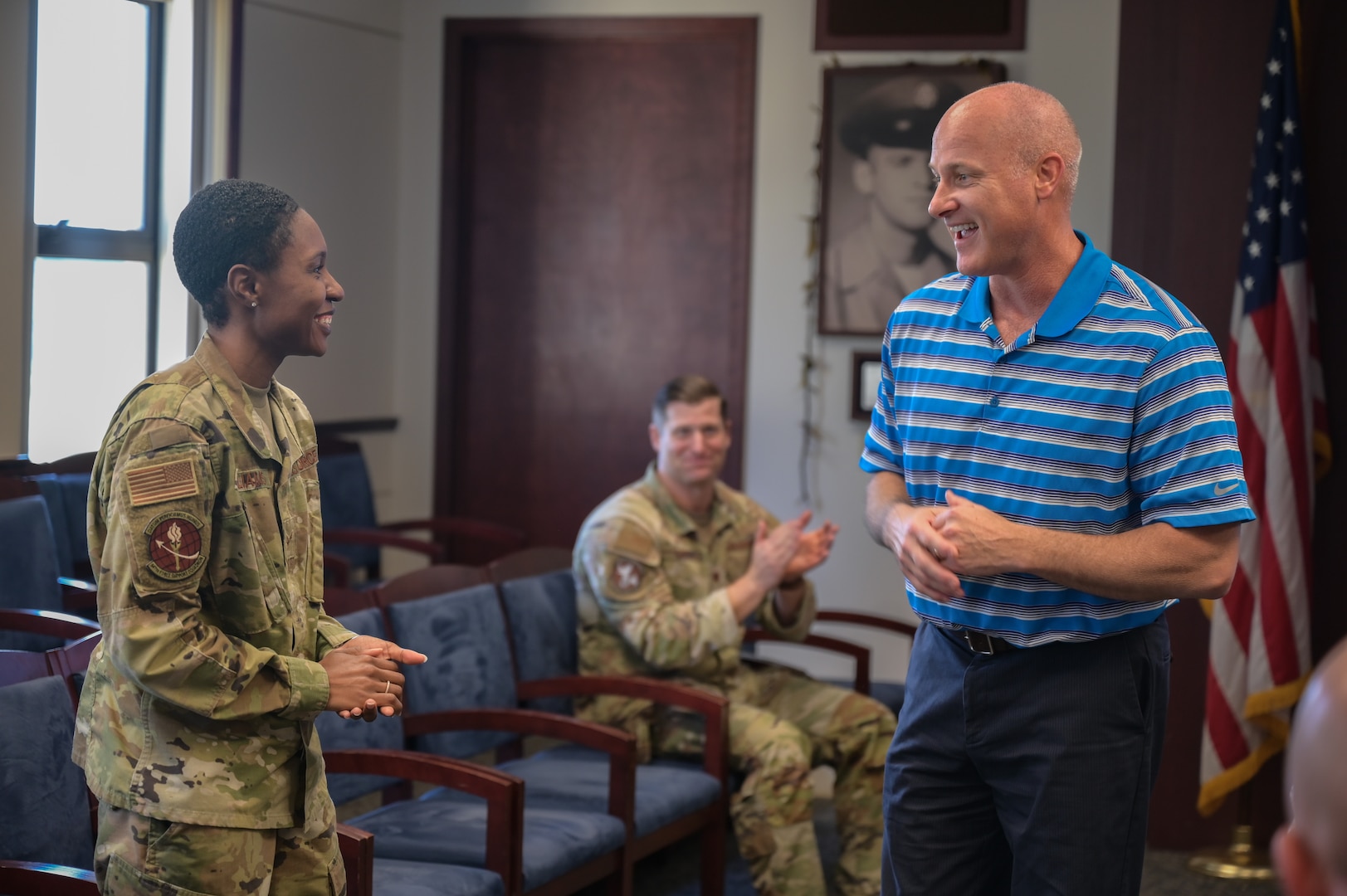 Senior Airman Chelsia Williams, 647th Force Support Squadron retentions technician, is coined by Sam Grable, Air Force Installation and Mission Support Center installation support directorate, in the 15th Wing Headquarters Building during a base visit on Joint Base Pearl Harbor-Hickam, Hawaii, Dec. 16, 2022. During the tour, Grable highlighted Airmen assigned to the 647th FSS, 15th Maintenance Group, 647th Civil Engineer Squadron and the 647th Logistics Readiness Squadron. (U.S. Air Force photo by Staff Sgt. Alan Ricker)