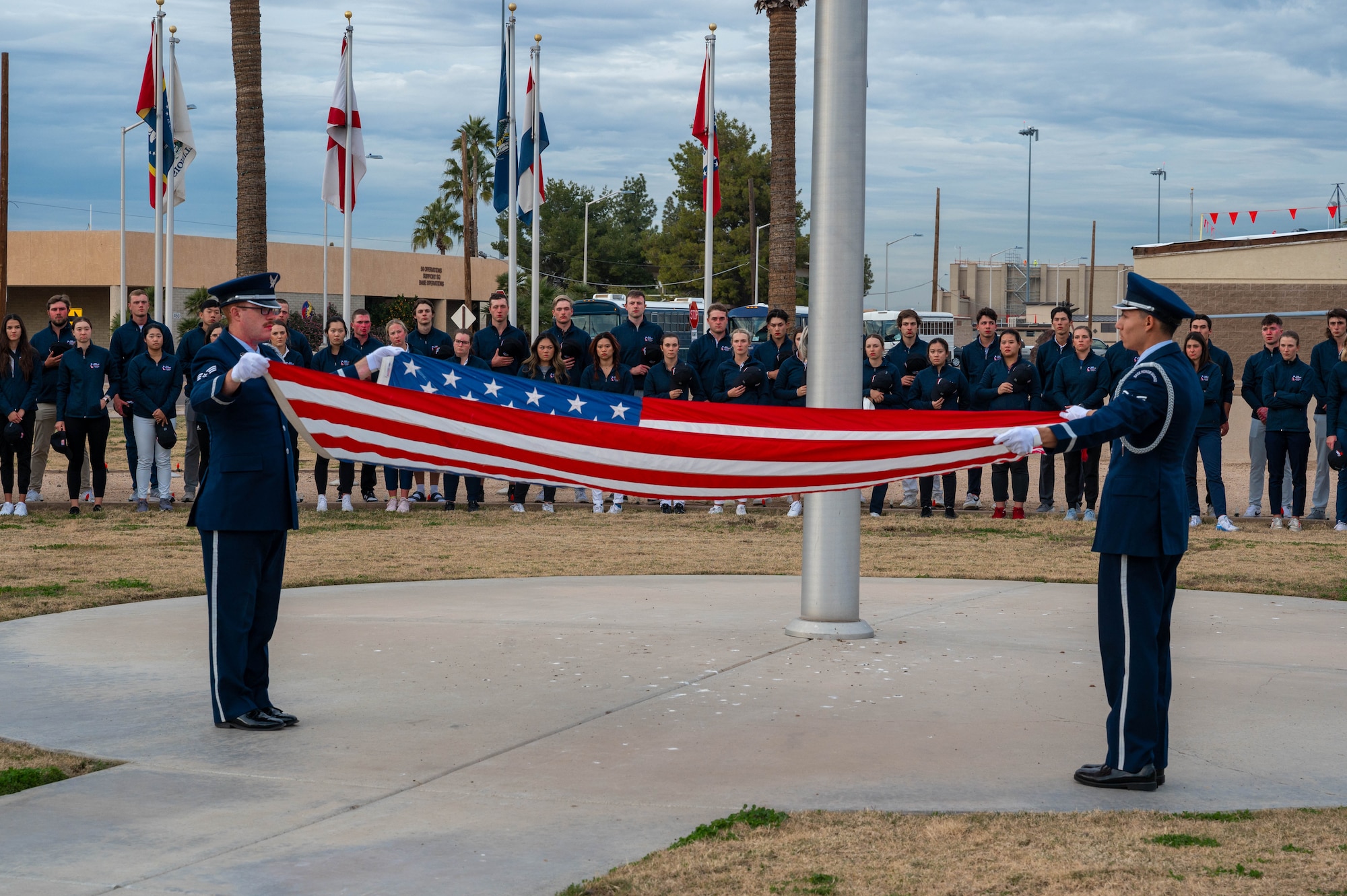 U.S. Air Force Senior Airman Trevor Schmitz and Airman 1st Class Alex Huerta, Luke Air Force Base guardsmen, fold the U.S. flag during a retreat ceremony, Dec. 27, 2022, at Luke AFB, Arizona.