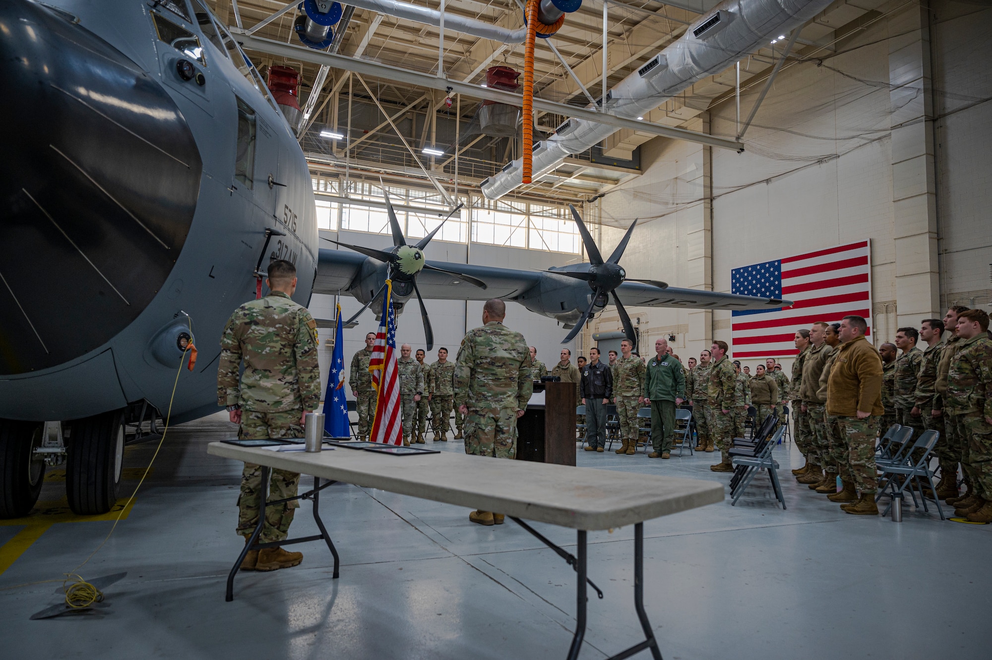 Airmen and leadership from the 317th Airlift Wing and 317th Maintenance Group stand at attention for the national anthem during the first Lethal Expeditionary Airman Development graduation at Dyess Air Force Base, Texas, Dec. 16, 2022. LEAD is a rigorous, locally developed course designed to create a more specialized, ready force that is better trained and equipped to support ACE objectives. LEAD provides added logistics capabilities in support of forward operations and does so with a significantly reduced footprint. (U.S. Air Force photo by Senior Airman Colin Hollowell)