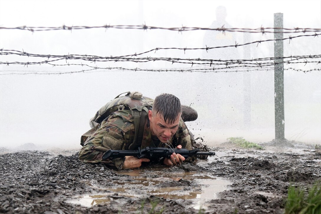 Spc. Patrick Kusik, an indirect fire infantryman assigned to 1st Battalion, 111th Infantry Regiment, 56th Stryker Brigade Combat Team, 28th Infantry Division, Pennsylvania Army National Guard low crawls under barbed wire while navigating an individual movement technique lane April 23 at Fort Indiantown Gap, Pa. Kusik attended a four-day Ranger Sapper Assessment Program and the IMT lane was an evaluated event. This event was designed to prepare the trainees for the infamous Malvesti obstacle course, a wet and muddy confidence course that they will encounter if selected to attend Ranger School. (U.S. Army National Guard photo by Staff Sgt. Shane Smith)