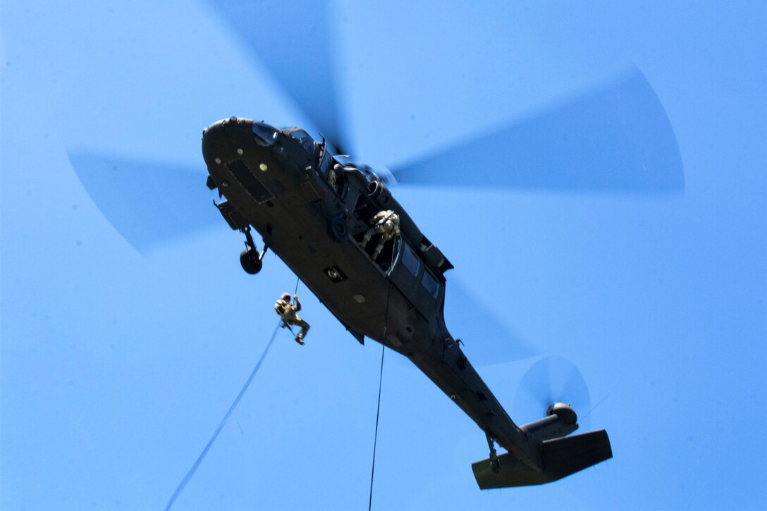 Soldiers from the 28th Expeditionary Combat Aviation Brigade hold the UH-60 Black hawk steady as Soldiers from the Headquarters and Headquarters Company, 1st Battalion, 110th Infantry Regiment, 2nd Infantry Brigade Combat Team, rappel down during training at Fort Indiantown Gap, Pa., on August 3, 2022. The rappel training was practice and preparation for the Soldiers to rappel from the Black Hawk onto a building (U.S Army photo by Sgt. 1st Class Matthew Keeler)