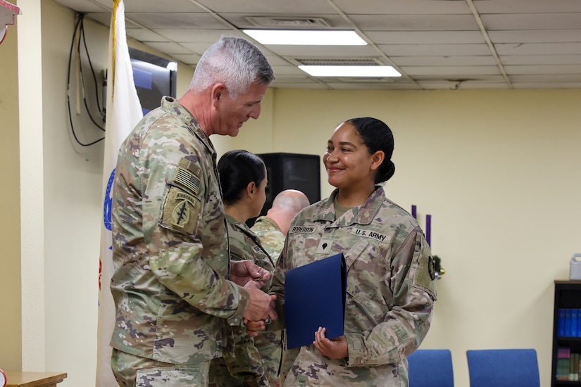 U.S. Army Command Sgt. Maj. Kevin Gaiser, the senior enlisted advisor of the 1st Theater Sustainment Command, congratulates the distinguished honor graduate, Spc. Jaclyn Roberts