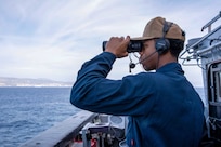 (Dec. 30, 2022) Operations Specialist 3rd Class Alec Sanders, assigned to the Ticonderoga-class guided-missile cruiser USS Leyte Gulf (CG 55), stands watch on the bridge wing as the ship arrives in Palma de Mallorca, Spain, for a scheduled port visit, Dec. 30, 2022. The George H.W. Bush Carrier Strike Group is on a scheduled deployment in the U.S. Naval Forces Europe area of operations, employed by U.S. Sixth Fleet to defend U.S., allied and partner interests.