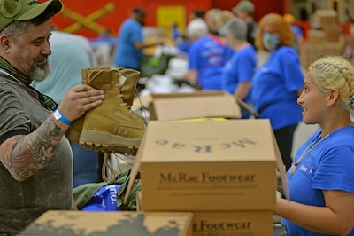 A man examines a pair of boots.