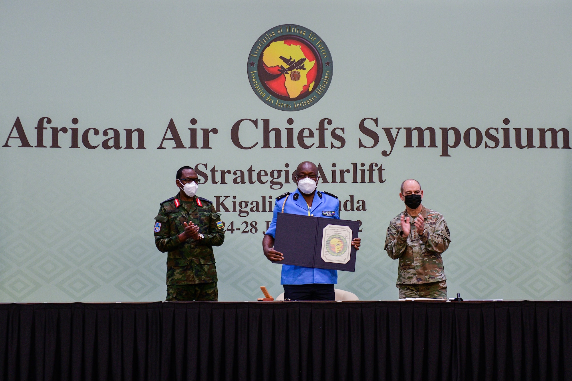 Gabonese Air Force Brig. Gen. Chief of Staff Mougnangui Jean Claude, Gabonese Air Force Chief of Staff, holds a signed charter to join the Association of African Air Forces with Rwandan Air Force Lt. Gen. Jean Jacques Mupenzi, Rwandan Air Chief of Staff, left, and U.S. Air Force Gen. Jeffrey Harrigian, U.S. Air Forces in Europe and Air Forces Africa commander, at the 2022 African Air Chiefs Symposium in Kigali, Rwanda, Jan. 26, 2022. The purpose of AAAF is to foster and strengthen the bonds of friendship, cooperation and mutual support in order to advance airpower on the African continent. The AAAF and its events provide the opportunity to engage multilaterally to promote accountable, rules-based organizations and institutions as we strengthen alliances and attract new partners. (U.S. Air Force photo by Senior Airman Brooke Moeder)