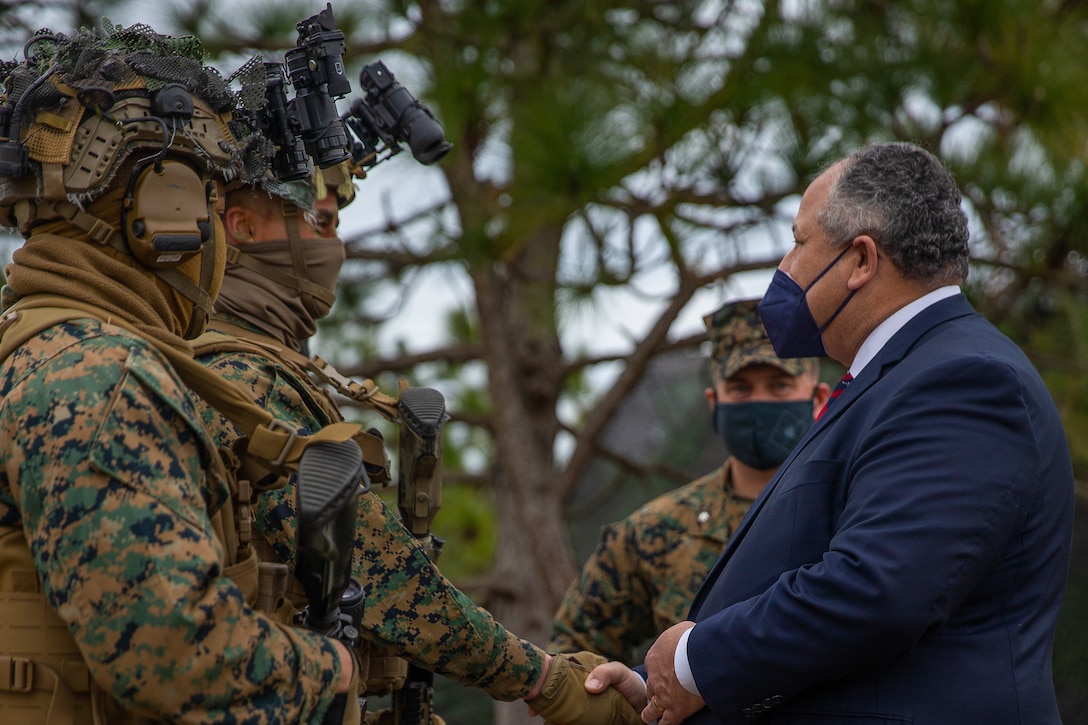 Secretary of the Navy Carlos Del Toro shakes hands with Marines during a live-fire demonstration of range G-36 at Camp Lejeune, North Carolina, Jan. 28, 2022.