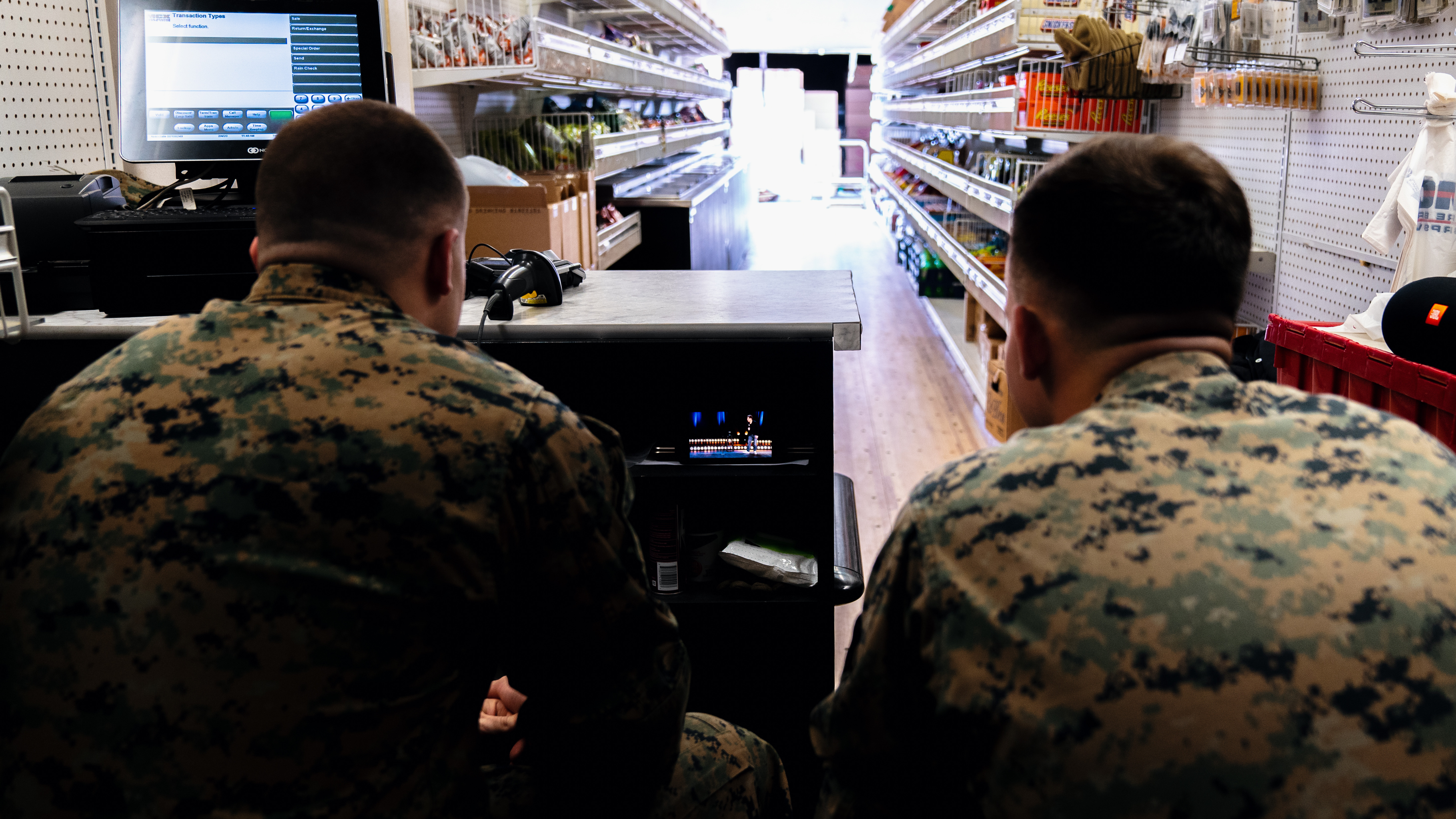 The back of two Marines sitting down.