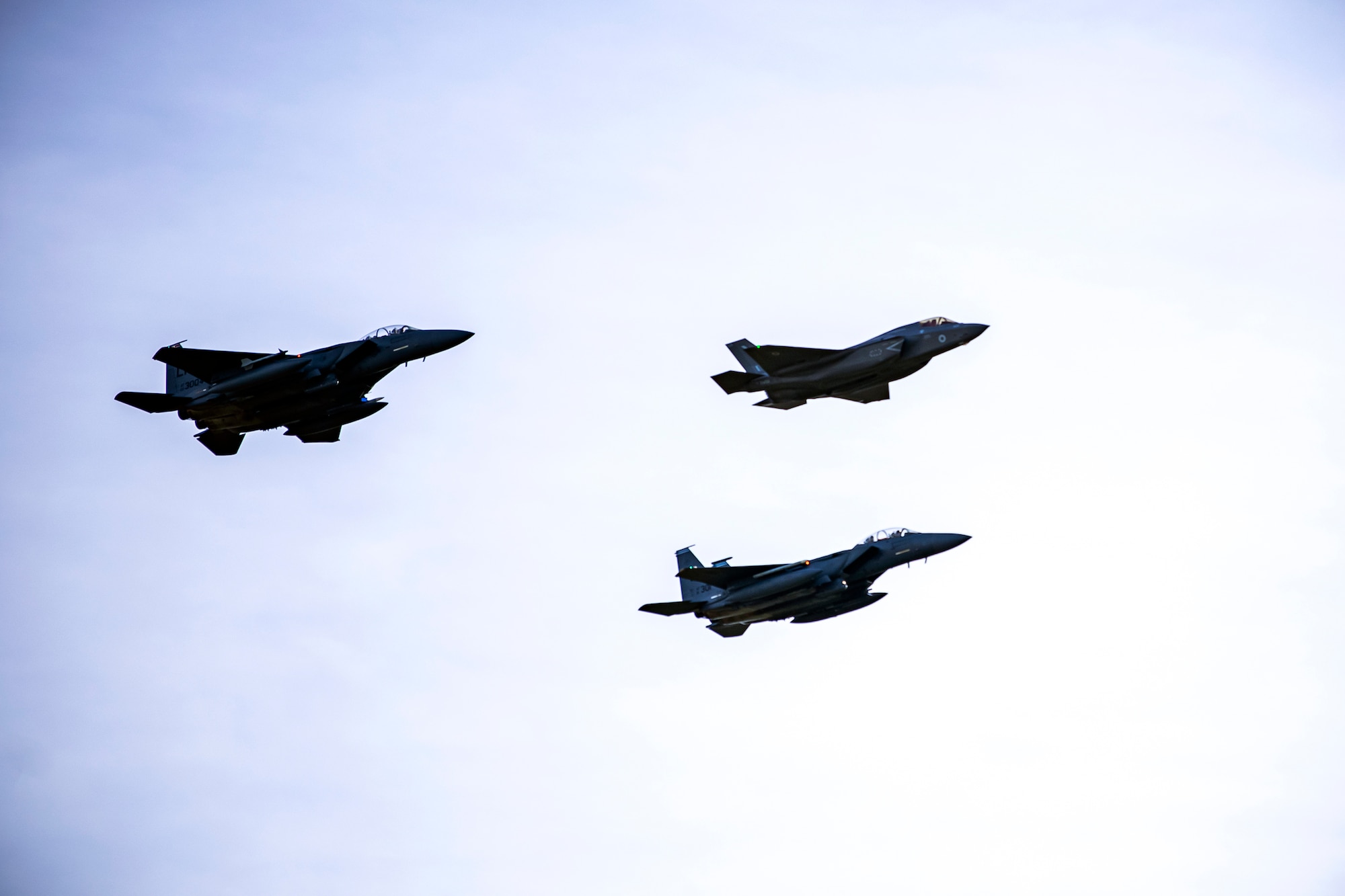 Two U.S. Air Force F-15 Strike Eagles along with a Royal Air Force F-35 aircraft in formation during a flyover at Duxford Airfield, England, Feb. 1, 2021. The flyover was in commemoration of the 80th anniversary of the Eighth Air Force. Events like these celebrate the continued USAF-RAF partnership and observe dissimilar U.S. and RAF aircraft integrating on approach to Duxford Airfield. (U.S. Air Force photo by Senior Airman Eugene Oliver)