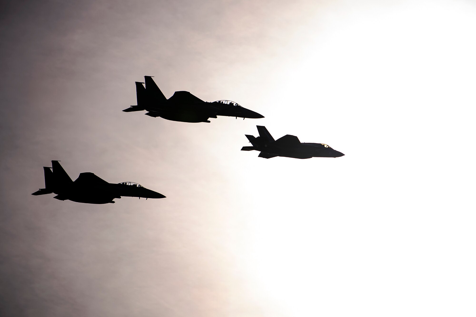 Two U.S. Air Force F-15 Strike Eagles along with a Royal Air Force F-35 aircraft in formation during a flyover at Duxford Airfield, England, Feb. 1, 2021. The flyover was in commemoration of the 80th anniversary of the Eighth Air Force. Events like these celebrate the continued USAF-RAF partnership and observe dissimilar U.S. and RAF aircraft integrating on approach to Duxford Airfield. (U.S. Air Force photo by Senior Airman Eugene Oliver)
