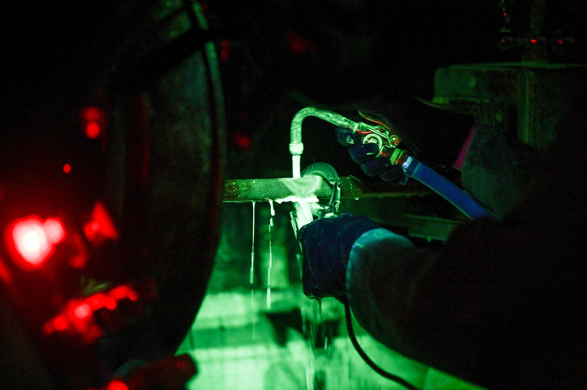 Airman 1st Class Dariel Maldonado, 15th Maintenance Squadron non-destructive inspections journeyman, applies liquid magnetic particles on an aerospace ground equipment hook at Joint Base Pearl Harbor-Hickam, Hawaii, Jan. 24, 2022. The hooks were a part of an annual magnetic particle inspection to ensure their serviceability. (U.S. Air Force photo by Staff Sgt. Alan Ricker)