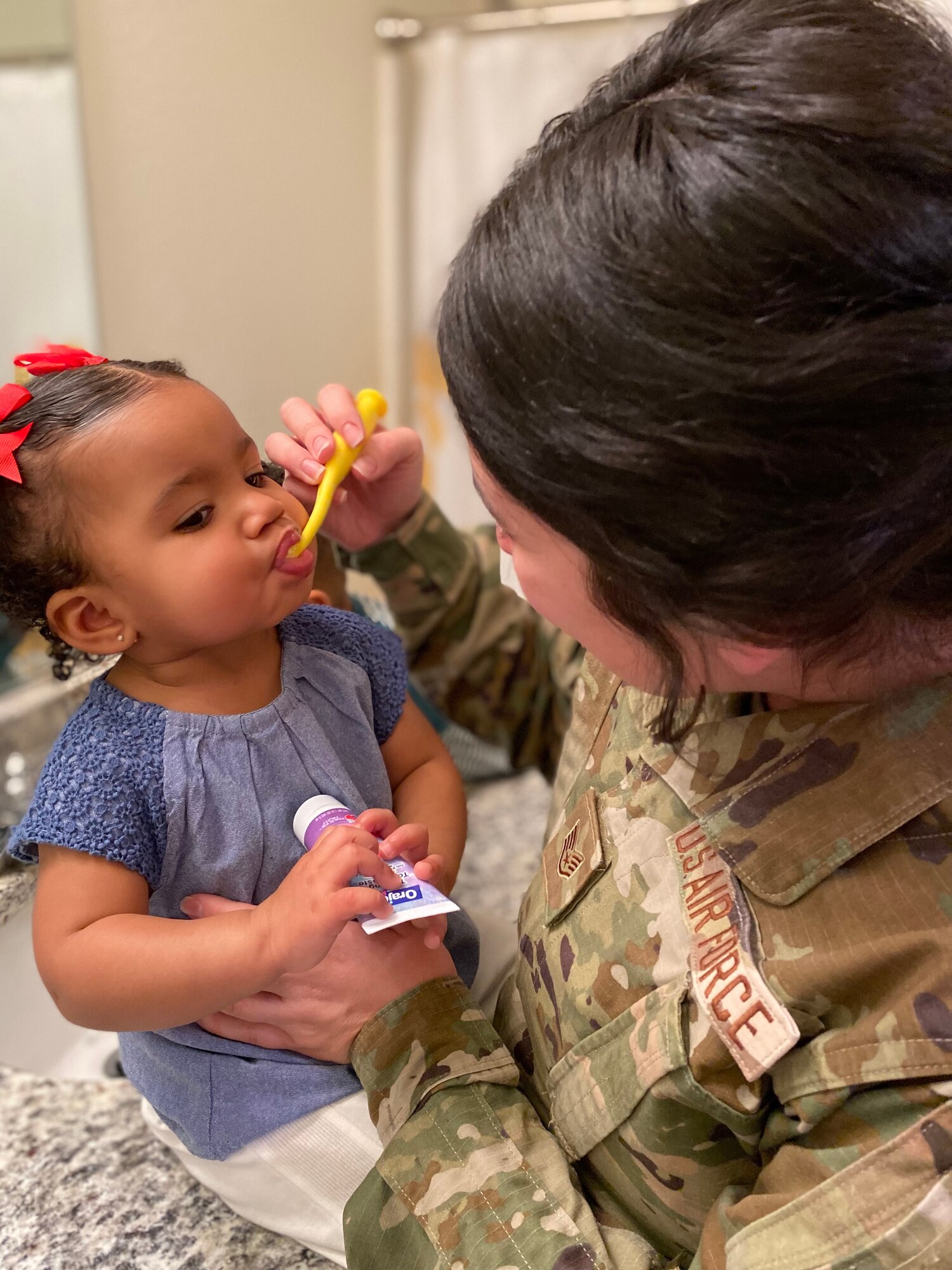 Person brushes child's teeth