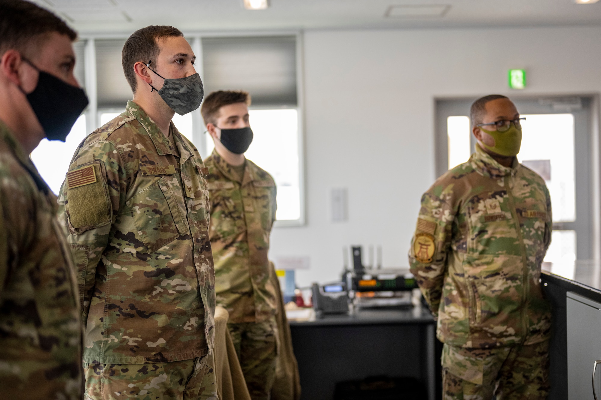 Four Airman standing at ease next to each other.