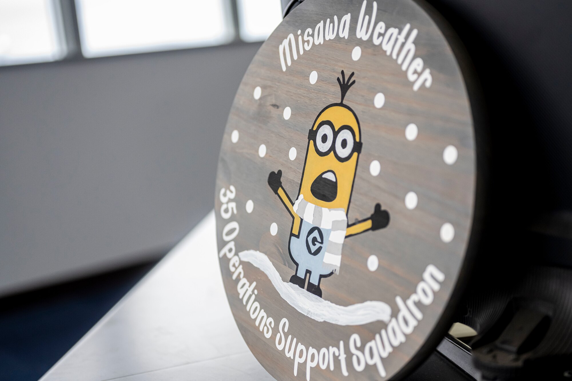 Emblem with white snow and yellow figure on it.