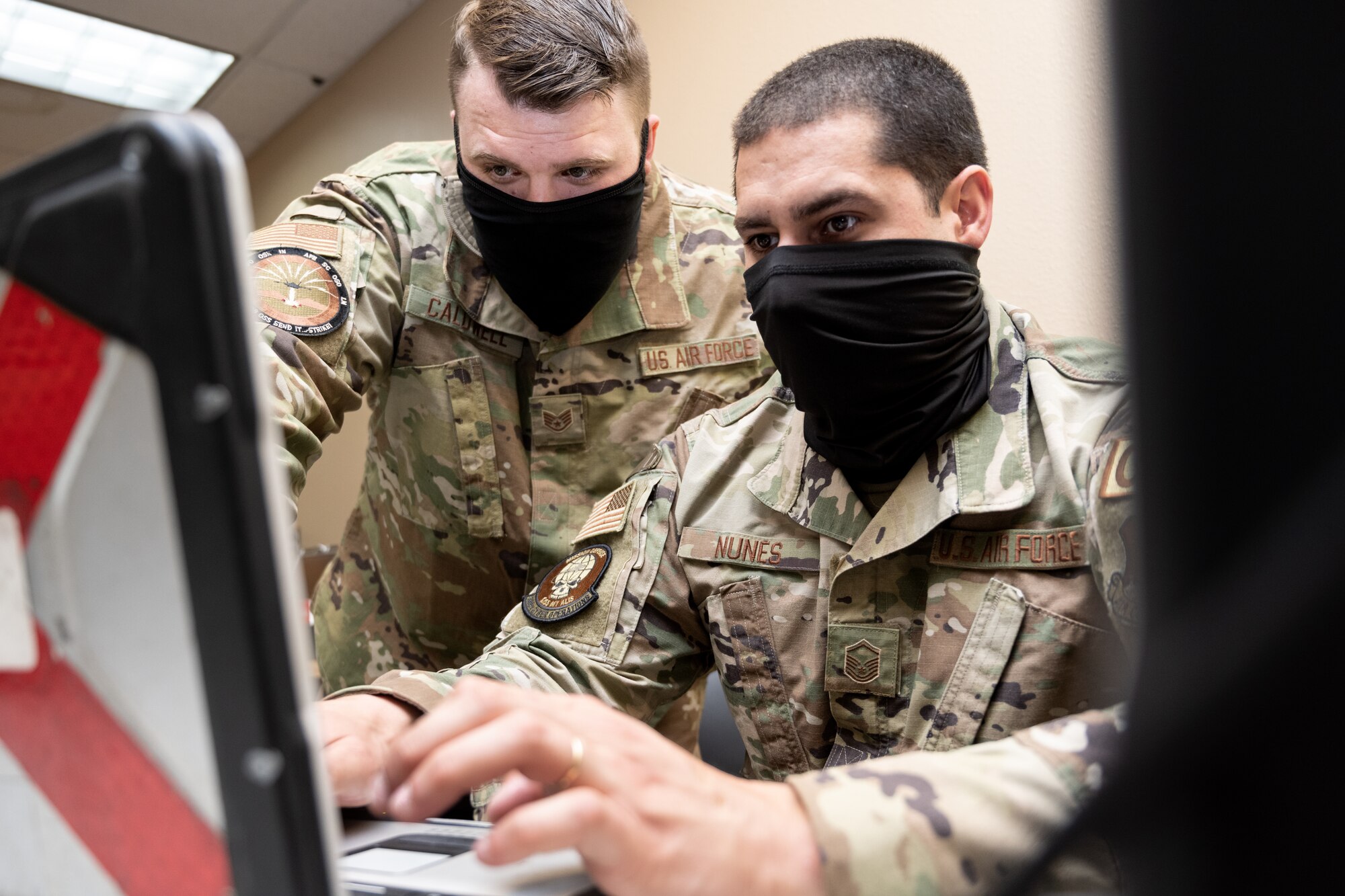 a photo of two cyber Airmen working on a computer
