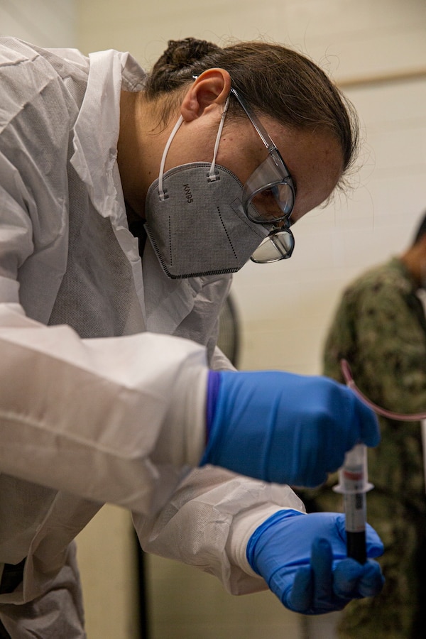 U.S. Navy Petty Officer 2nd Class Maria Potts-Szoke, a hospital corpsman with the Naval Medical Research Center Silver Spring, collects blood samples on Camp Foster, Okinawa, Japan, Jan. 24, 2022. The COVID-19 Health Action Response for Marines study was founded in May 2020 to assist the Marine Corps manage the COVID-19 outbreaks at the recruit depots and to monitor the health of recruits who tested positive for the virus. The second iteration of the study was launched soon after, and deployed to over 15 bases around the U.S. and in Okinawa to follow up and monitor the long-term effects those recruits, now Marines, may be experiencing. (U.S. Marine Corps photo by Lance Cpl. Alex Fairchild)