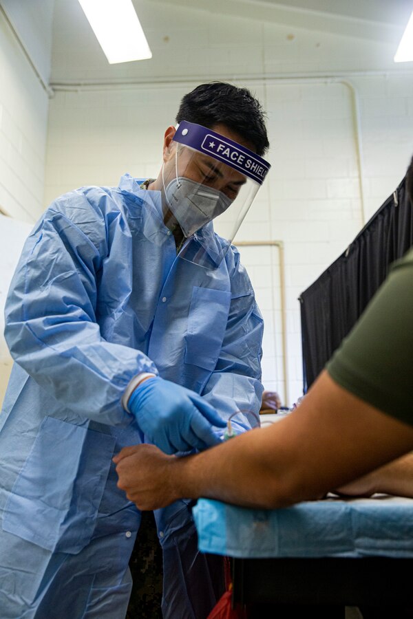 U.S. Navy Chief Petty Officer Jan Marayag, a laboratory chief with the Naval Medical Research Center Silver Spring, collects blood samples on Camp Foster, Okinawa, Japan, Jan. 24, 2022. The COVID-19 Health Action Response for Marines study was founded in May 2020 to assist the Marine Corps manage the COVID-19 outbreaks at the recruit depots and to monitor the health of recruits who tested positive for the virus. The second iteration of the study was launched soon after, and deployed to over 15 bases around the U.S. and in Okinawa to follow up and monitor the long-term effects those recruits, now Marines, may be experiencing. (U.S. Marine Corps photo by Lance Cpl. Alex Fairchild)