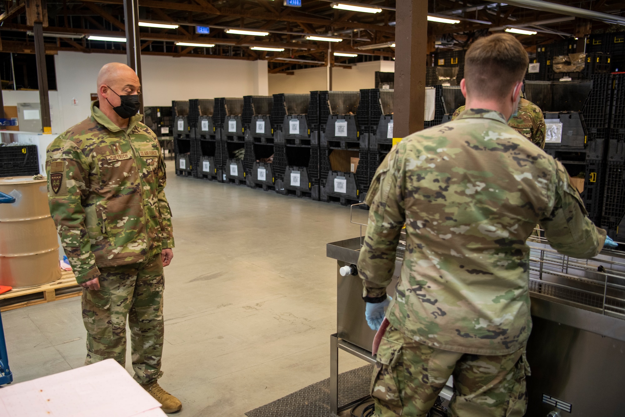 U.S. Air Force Brig. Gen. George T. Dietrich III, U.S. Air Forces in Europe - Air Forces Africa director of logistics, engineering and force protection, left, receives a brief from Airman 1st Class Gaige Goodwin, 52nd Logistic Readiness Squadron individual protective equipment journeyman, on a weapons cleaning innovation, Jan. 25, 2022, at Spangdahlem Air Base, Germany.