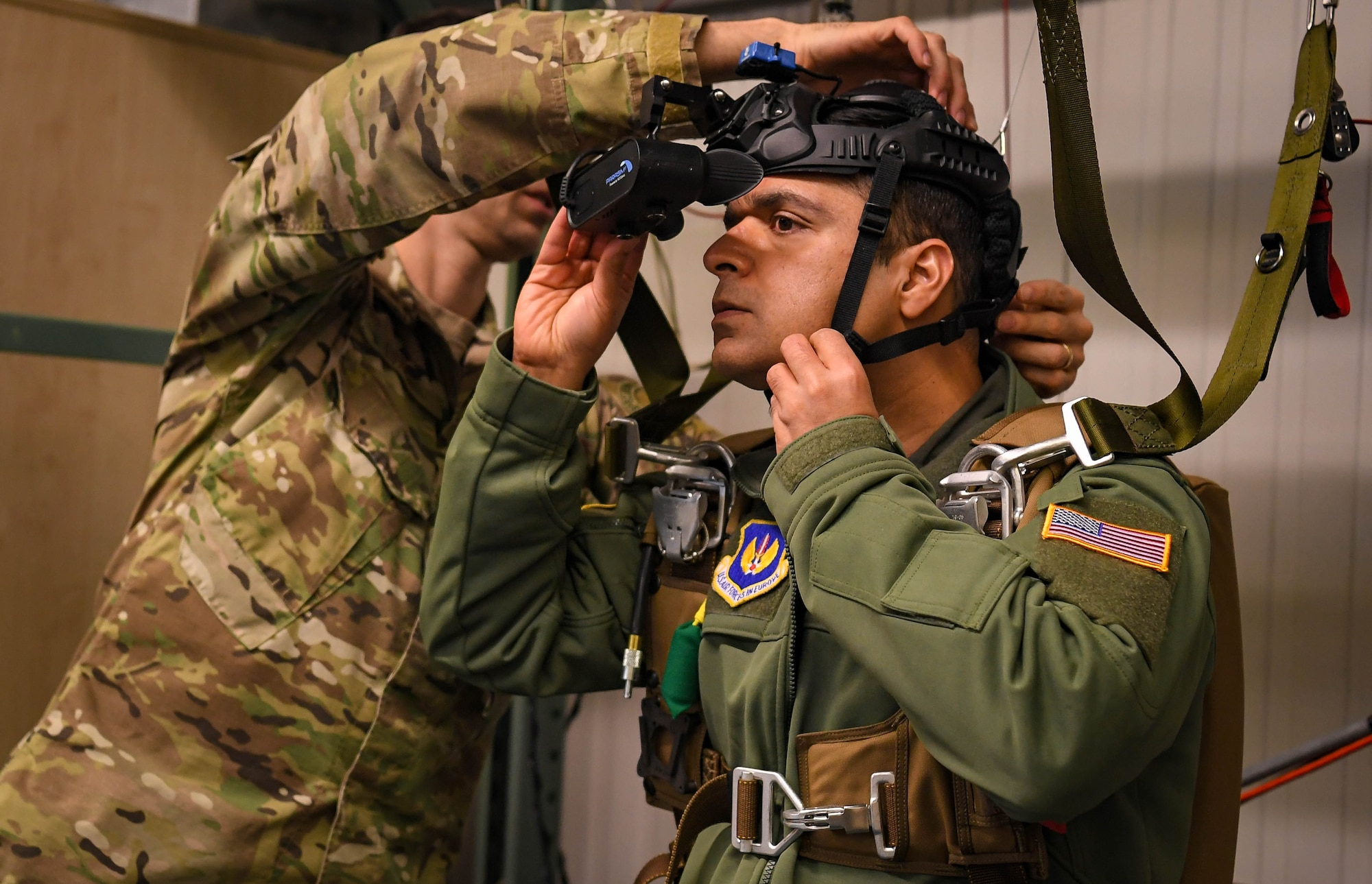 U.S. Air Force Staff Sgt. John Lynch, 86th Operations Support Squadron survival, evasion, resistance and escape specialist, removes the parasim virtual reality parachute training simulator equipment from Capt. Vikas Kumar, 86 OSS aircrew flight equipment chief wing aerospace physiologist, at Ramstein Air Base, Germany, Jan. 27, 2022. The parasim is a virtual reality simulator that allows the trainee to experience an emergency parachute event in a controlled environment. (U.S. Air Force photo by Airman 1st Class Jared Lovett)