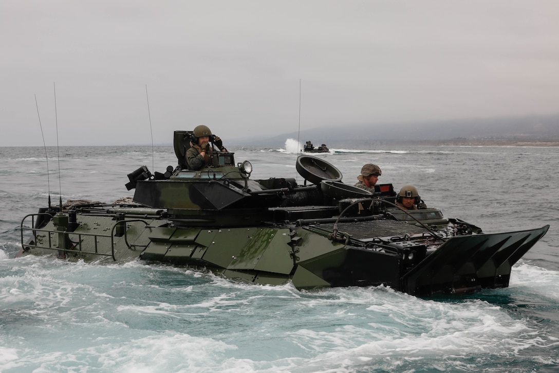 U.S. Marines with Co. A, 1st Battalion, 5th Marines, 1st Marine Division (1st MARDIV), and Co. B, 3d Assault Amphibian Battalion, 1st MARDIV, prepare to evacuate a P7/A1 assault amphibious vehicle (AAV) during a surf qualification at Marine Corps Base Camp Pendleton, California, June 30, 2021. The qualification training included a 1,000-meter swim to shore from an AAV. (U.S. Marine Corps photo by Lance Cpl. Cameron Hermanet)
