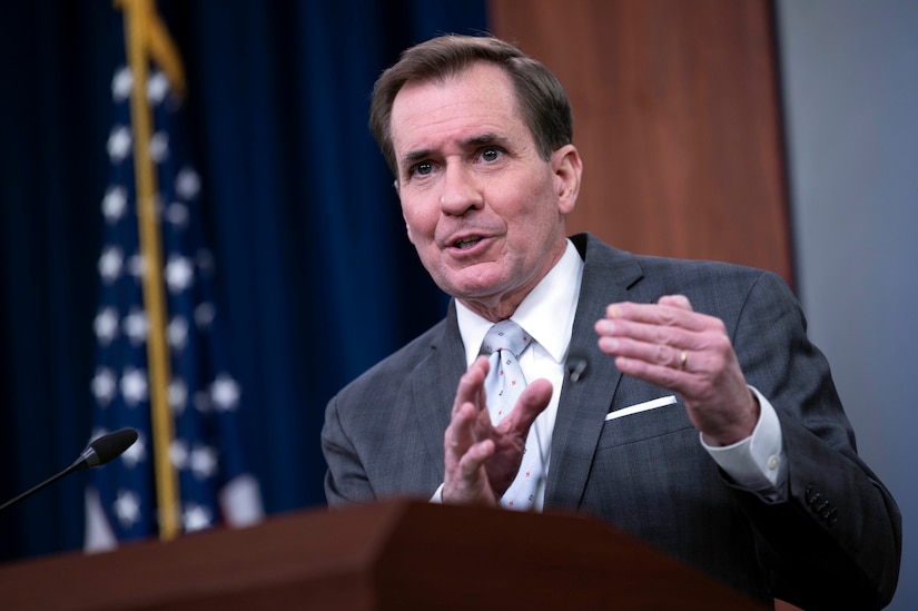 A man gesticulates while speaking at a lectern.