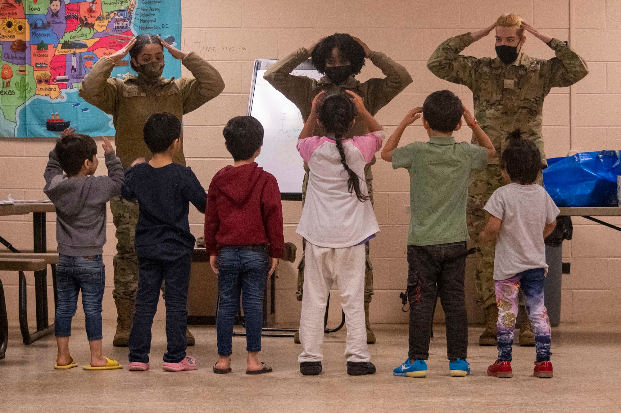 Airmen from the 445th Airlift Wing and 88th Air Base Wing assigned to Task Force-Liberty, sing the “head, shoulders, knees and toes” song with Afghan children in Liberty Village on Joint Base McGuire-Dix-Lakehurst, New Jersey, Feb. 1, 2022. The Department of Defense, through U.S. Northern Command, and in support of the Department of Homeland Security, is providing transportation, temporary housing, medical screening, and general support for at least 11,000 Afghan evacuees at Liberty Village, in permanent or temporary structures, as quickly as possible. This initiative provides Afghan personnel essential support at secure locations outside Afghanistan.