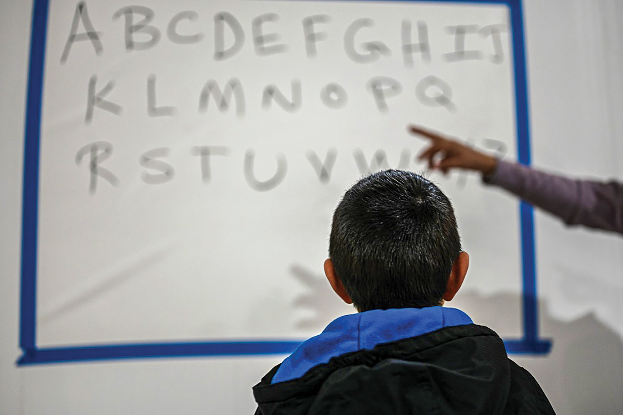 A teacher instructs Afghan students during the first day of community-based education in Liberty Village, Joint Base McGuire-Dix-Lakehurst, New Jersey, Dec. 20, 2021.