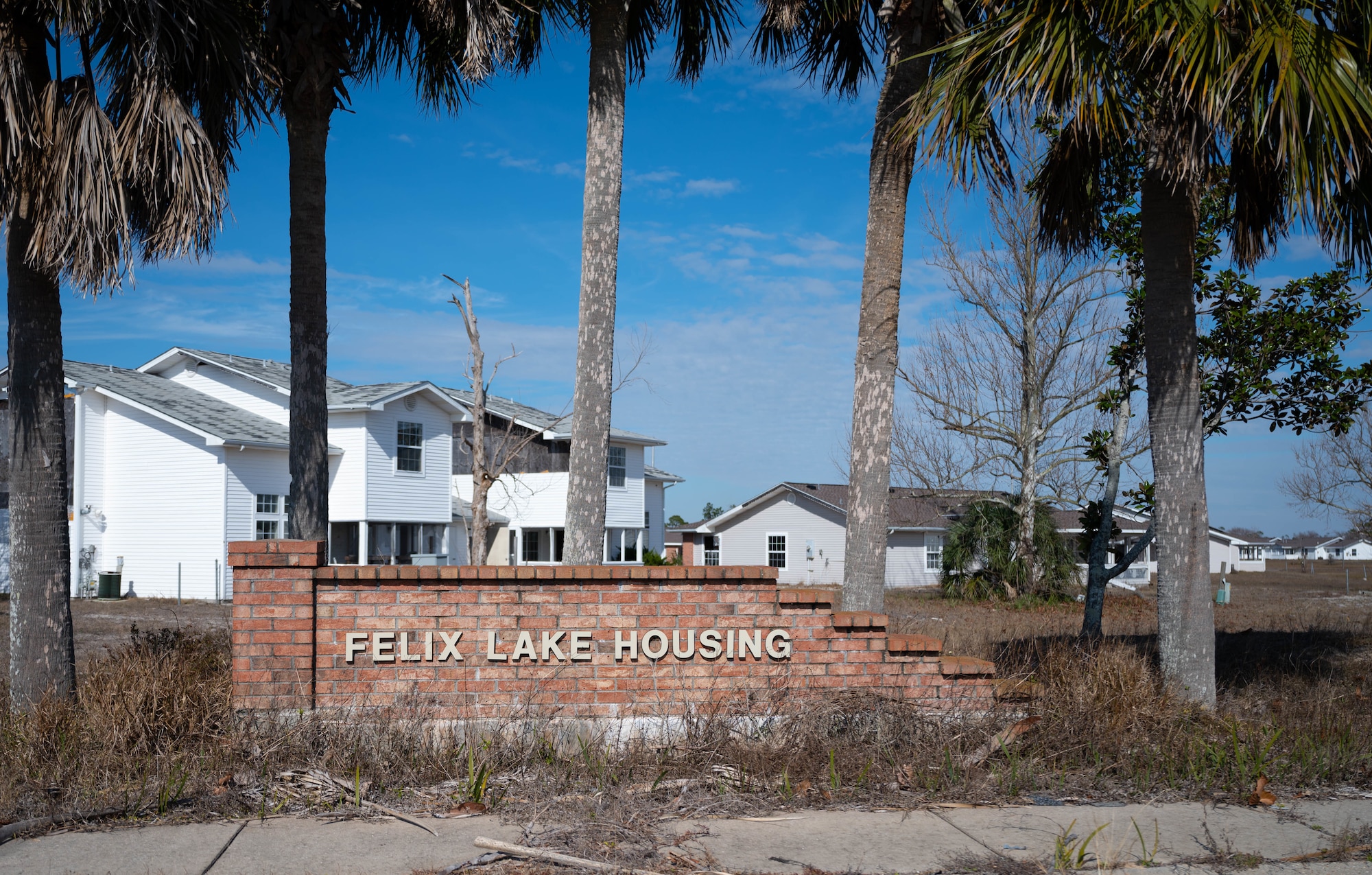 A sign sits outside a housing area.