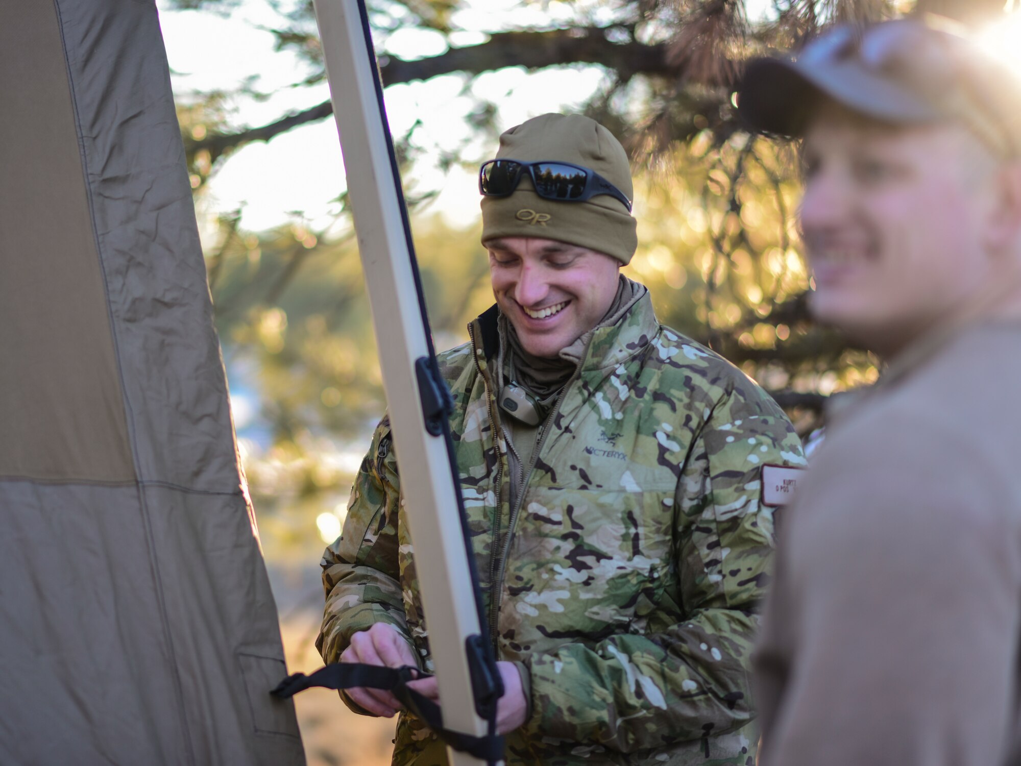 a photo of an Airman setting up a tent