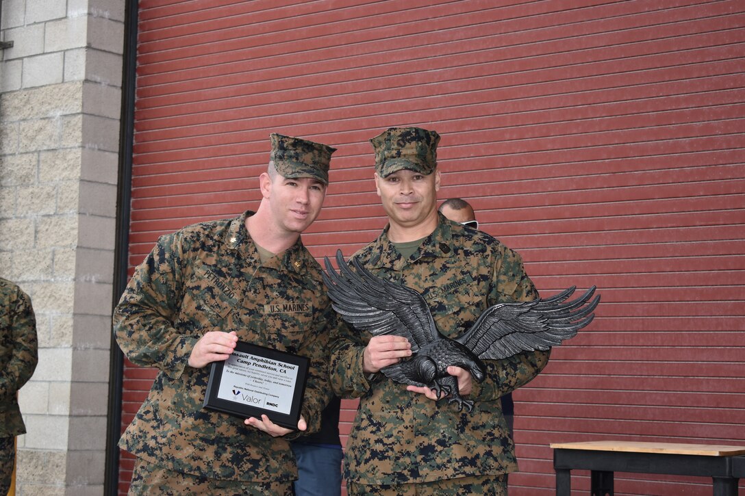 U.S. Marine Corps SgtMaj Earl Budd, AAS Sergeant Major, and Maj Daniel Petronzio, AAS Executive Officer for Assault Amphibian School, accept a plaque from the volunteers and their families from RNDC.