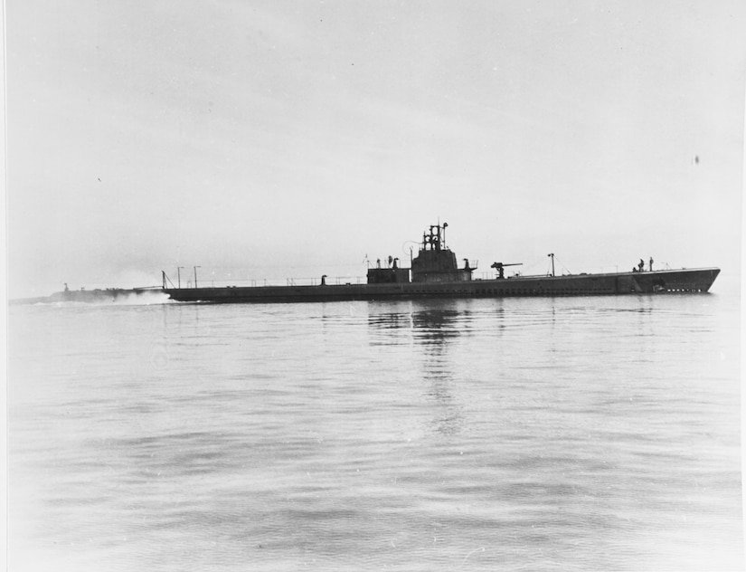 A submarine sits on the surface of the ocean.