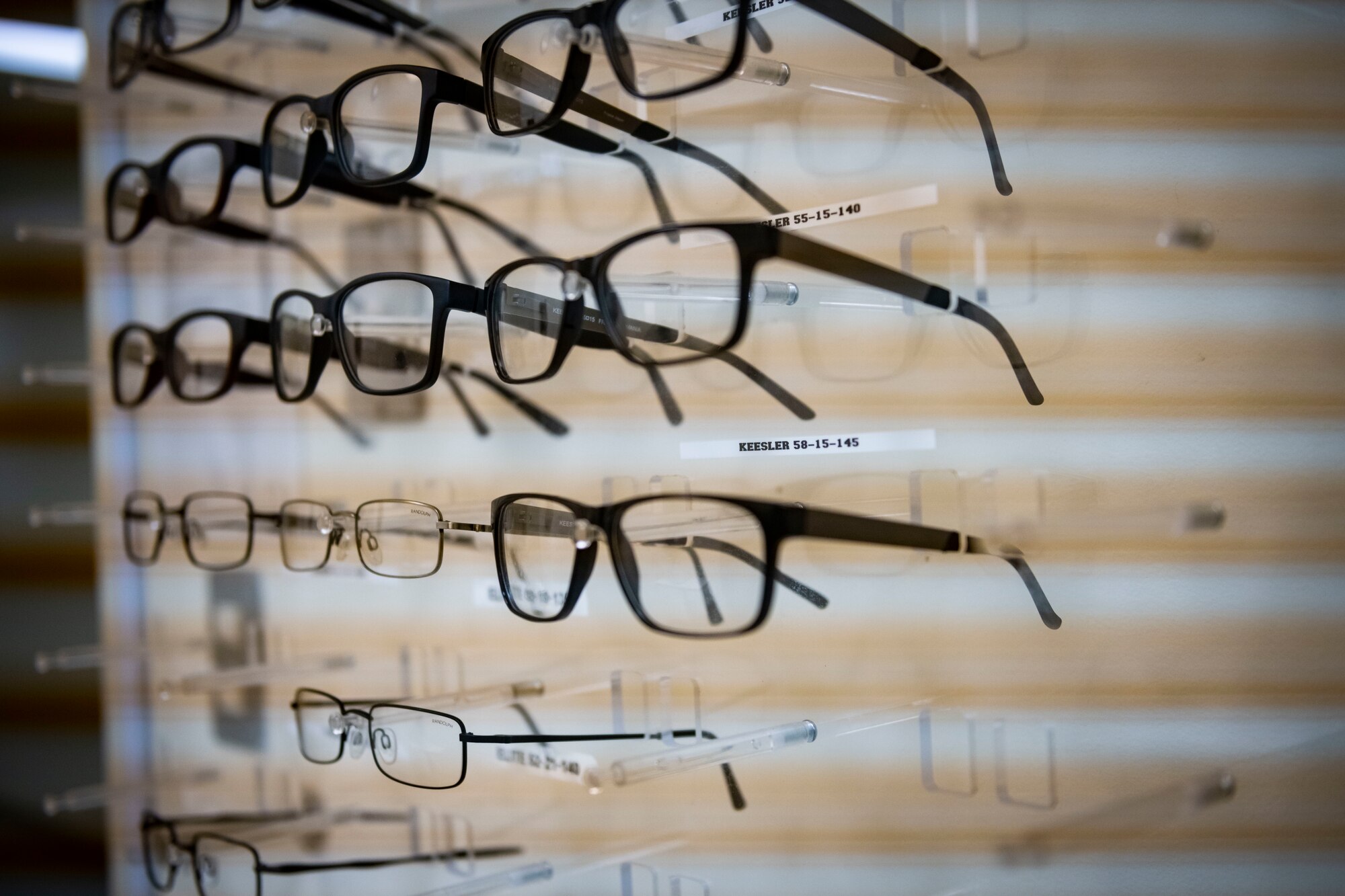Multiple eye glasses sit on a display.