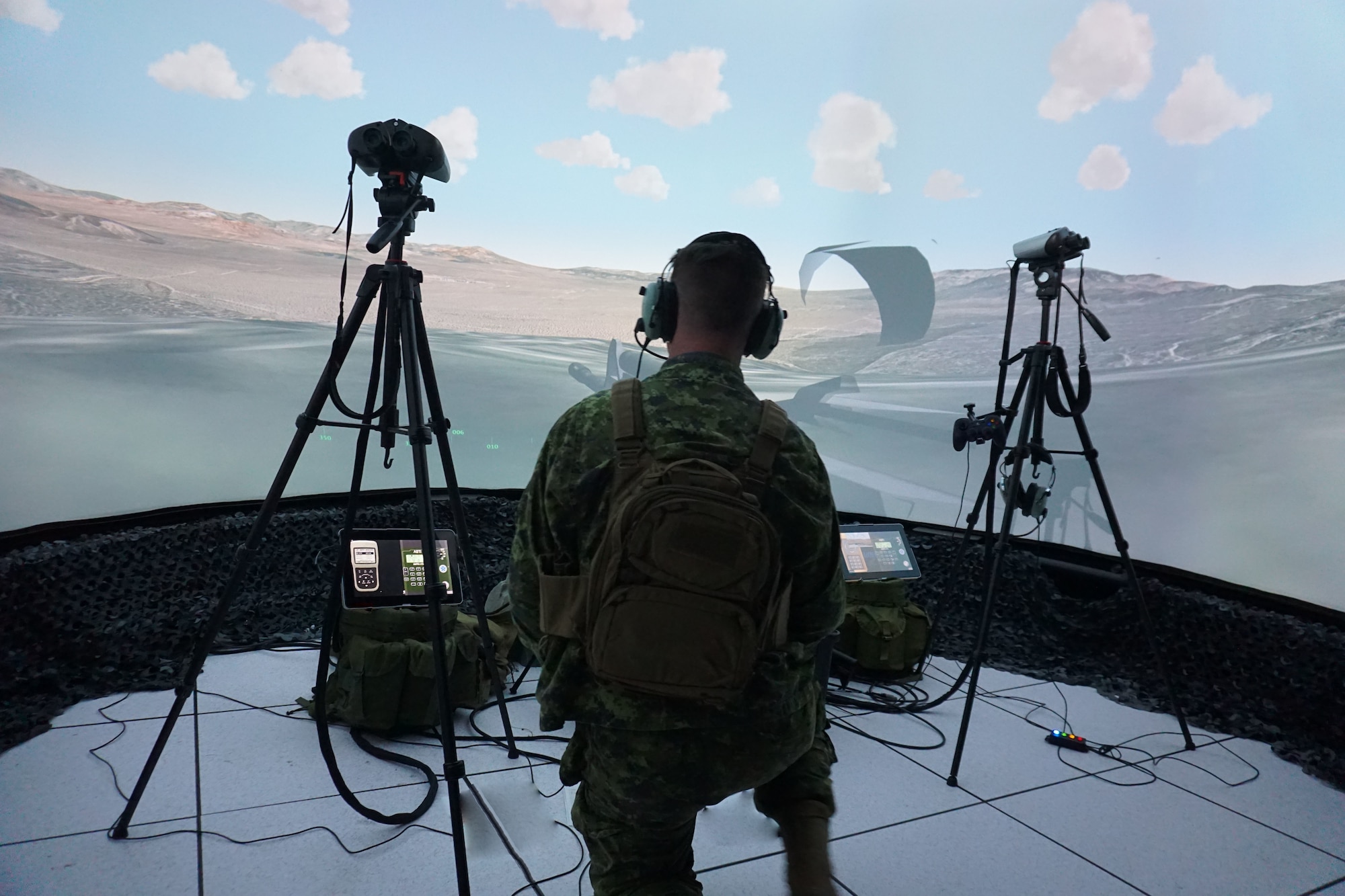 A Canadian coalition tactical air control party member operates within a simultaneously live, virtual, and constructive environment allowing warfighters to prepare to wage war, and then practice doing so in a realistic simulation so that they can learn how to be combat effective during Coalition VIRTUAL FLAG 22-1 at Kirtland Air Force Base, New Mexico, Oct. 24 - Nov. 5, 2021. CVF exercises led by the United States Air Force focus on coalition major combat operations in a realistic theater against a near-peer threat in a dynamic training environment. CVFs are designed to build and maintain joint and coalition partnerships between the United States, United Kingdom, Australia, and Canada by focusing on planning, executing, and debriefing a multitude of mission sets in air, space, surface, and cyber domains. (This photo has been altered for security purposes by removing monitor screens and paperwork on the floor.) (U.S. Air Force photo by Deb Henley)