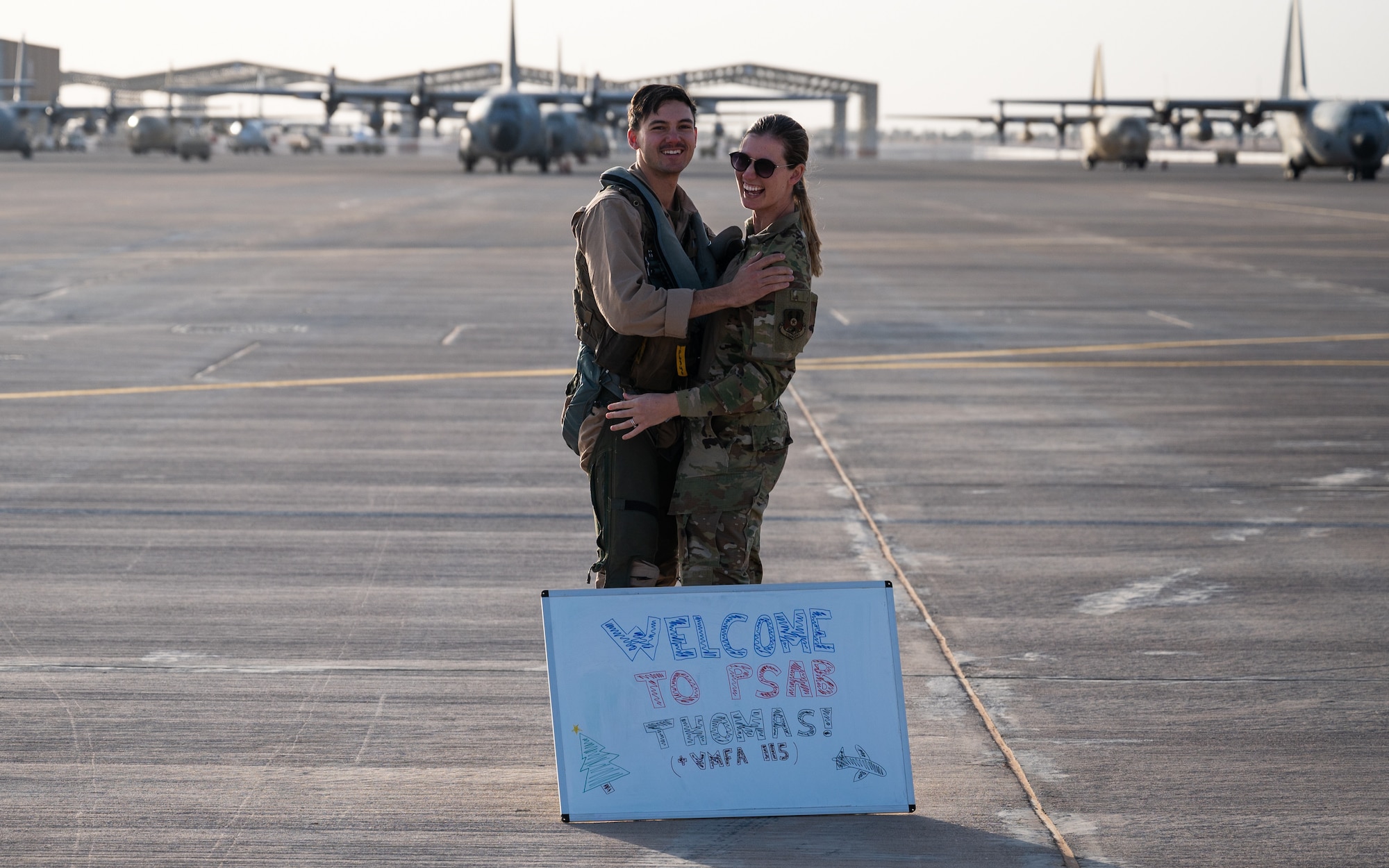 U.S. Marine Capt. Thomas Phillips, Marine Fighter Attack Squadron 115 weapons system officer, hugs his wife U.S. Air Force 1st Lt. Alyson Phillips, 378th Expeditionary Contracting Squadron infrastructure flight commander, after their reunion on the flight line of Prince Sultan Air Base, Kingdom of Saudi Arabia. Thomas and Alyson were both tasked by their respective branches to deploy to PSAB. (U.S. Air Force photo by Senior Airman Jacob B. Wrightsman)