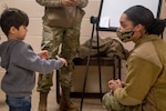 Senior Airman Taylor McAfee, financial operations technician, 88th Comptroller Squadron, currently assigned as Task Force-Liberty Joint Readiness Center non-medical escort, teaches English phrases to Afghan children in Liberty Village on Joint Base McGuire-Dix-Lakehurst, New Jersey, Feb. 1, 2022. The Department of Defense, through U.S. Northern Command, and in support of the Department of Homeland Security, is providing transportation, temporary housing, medical screening, and general support for at least 11,000 Afghan evacuees at Liberty Village, in permanent or temporary structures, as quickly as possible. This initiative provides Afghan personnel essential support at secure locations outside Afghanistan