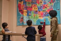 Senior Airman Cicely McWhorter, 87th Aerial Port Squadron passenger services apprentice, currently assigned as Task Force-Liberty Joint Readiness Center floor operations, teaches Afghan children the names of the 50 states in Liberty Village on Joint Base McGuire-Dix-Lakehurst, New Jersey, Feb. 1, 2022. The Department of Defense, through U.S. Northern Command, and in support of the Department of Homeland Security, is providing transportation, temporary housing, medical screening, and general support for at least 11,000 Afghan evacuees at Liberty Village, in permanent or temporary structures, as quickly as possible. This initiative provides Afghan personnel essential support at secure locations outside Afghanistan.