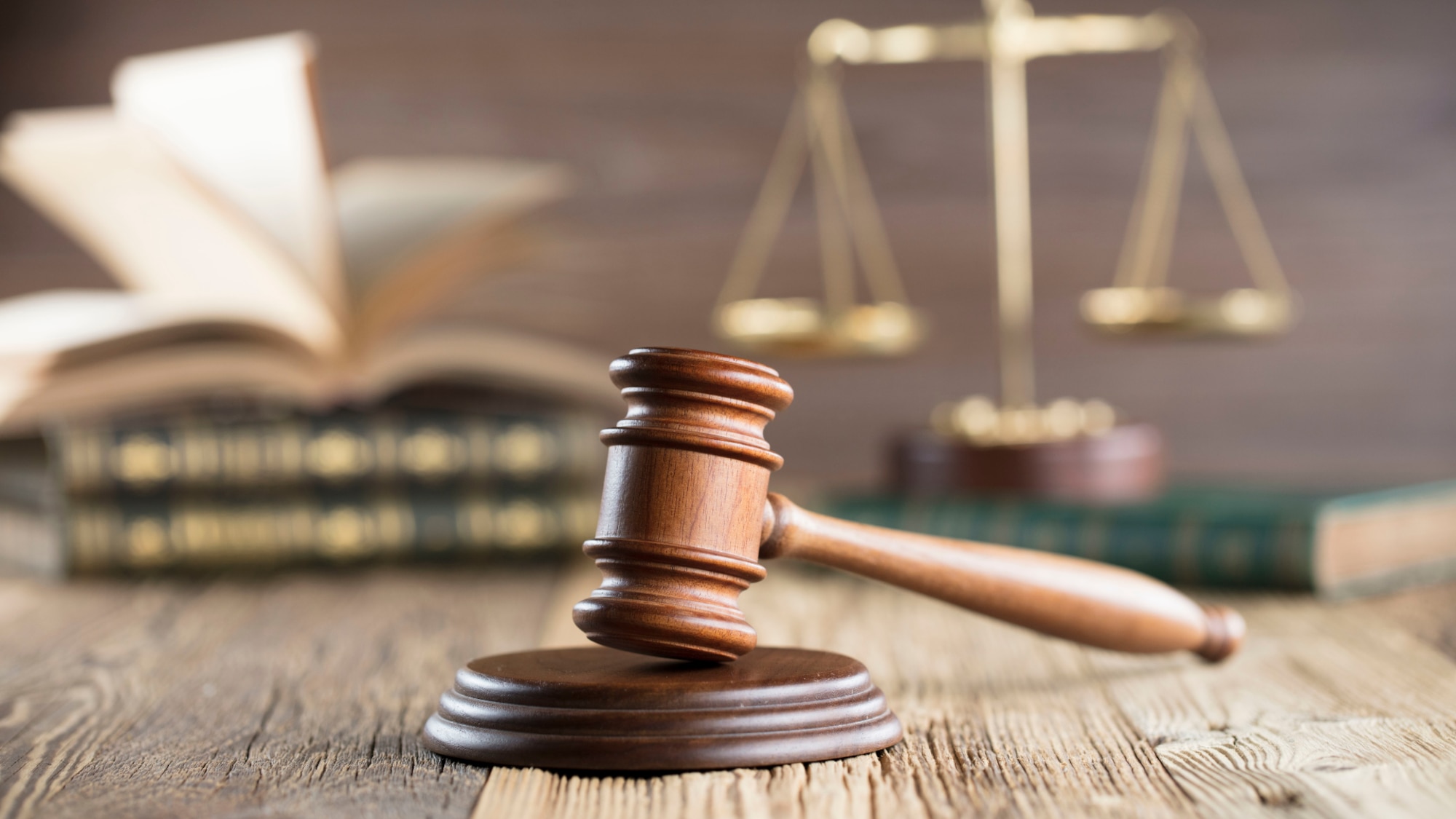 Gavel is at the forefront and the legal books are blurred in the background