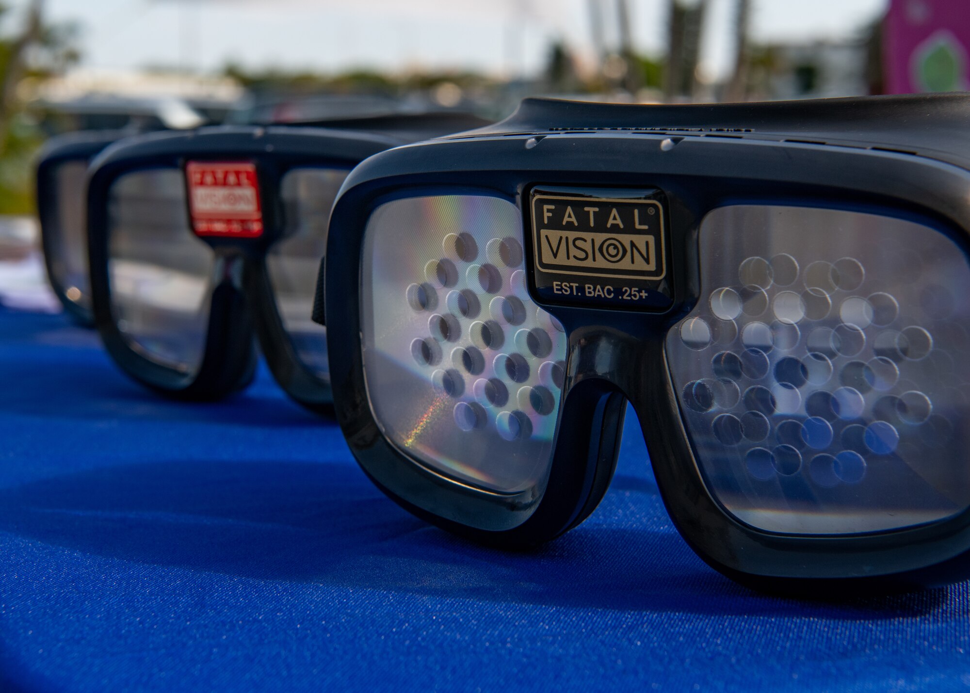 Three vision impairment goggles lie on a table.