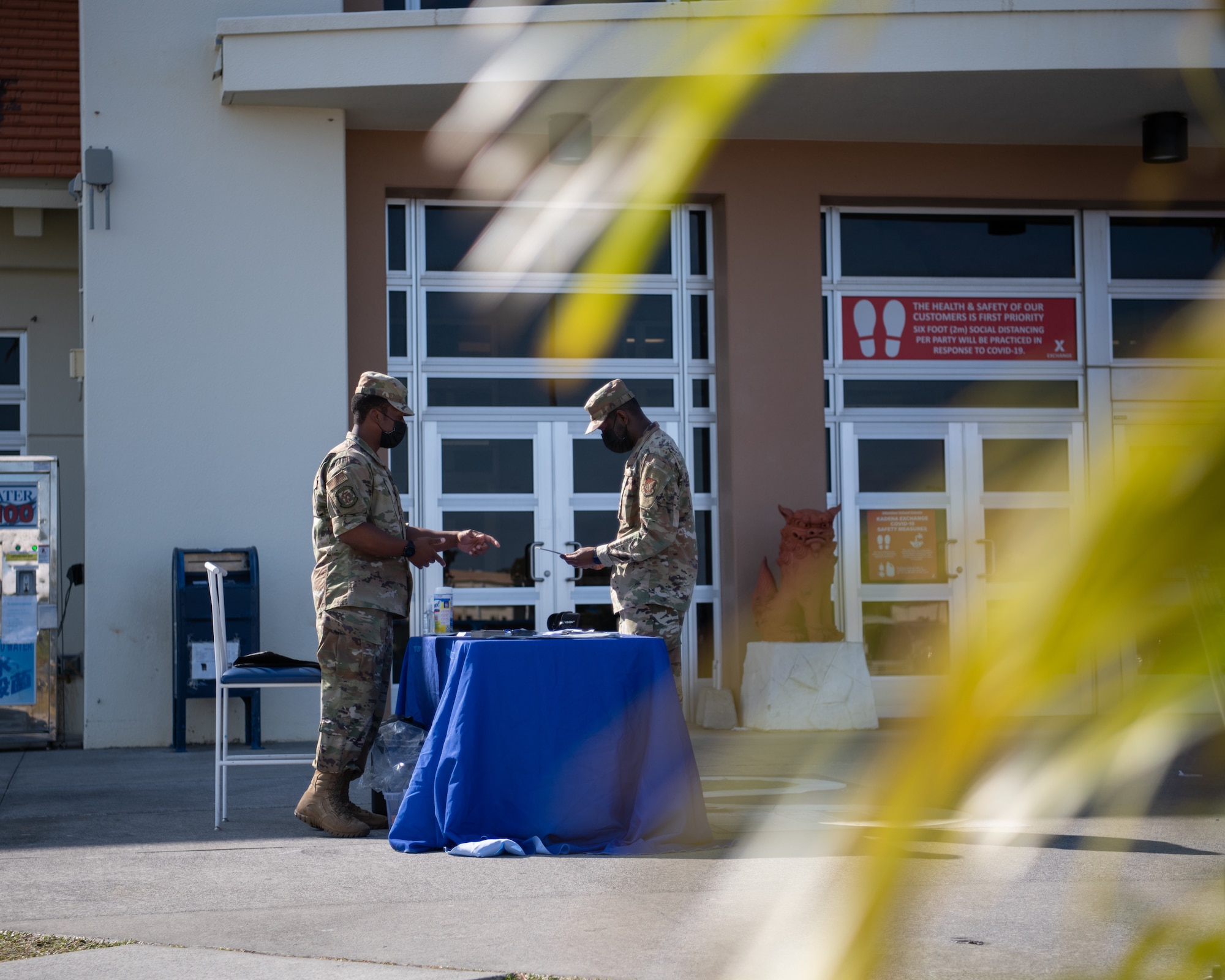 Two Airmen look at materials on a table.