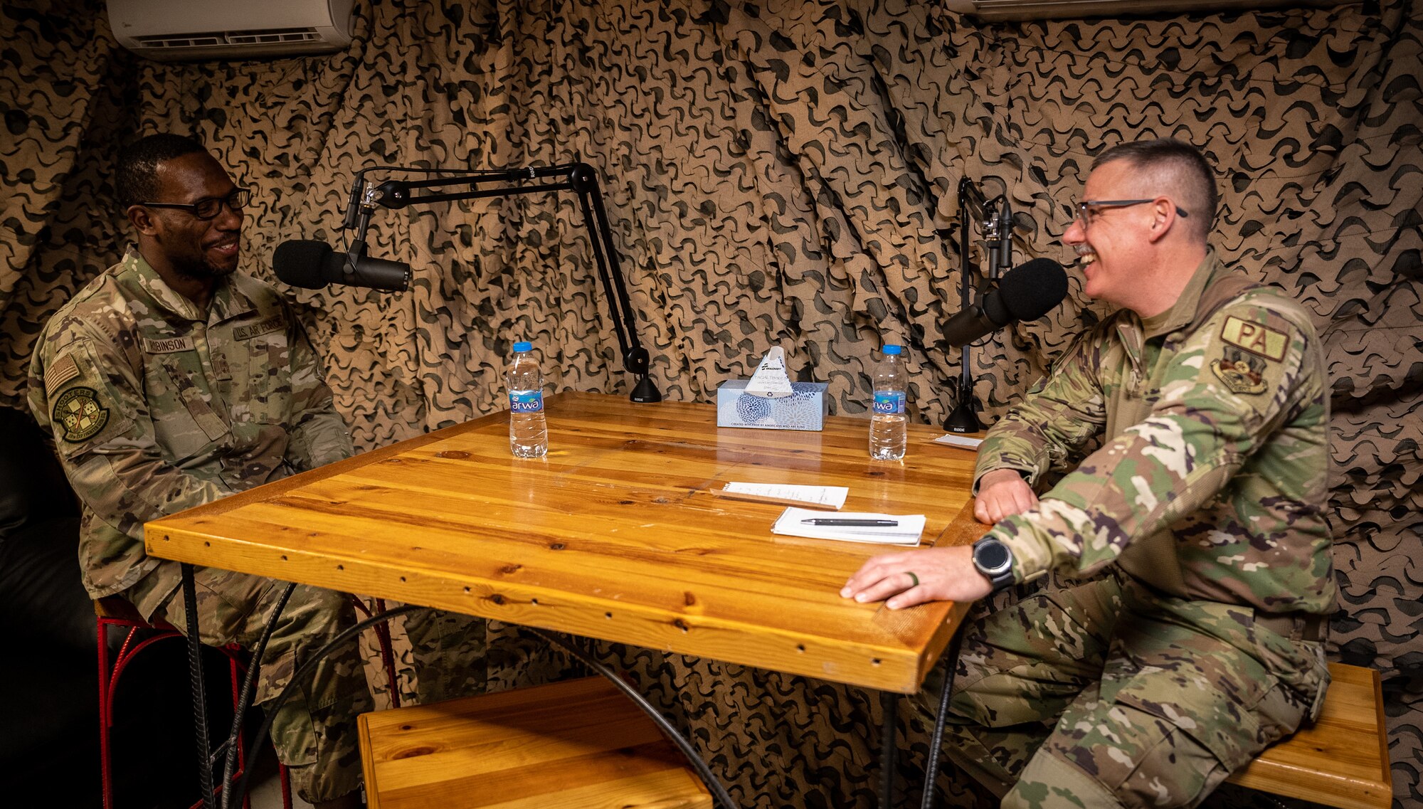 Master Sgt. Teko Robinson, 55th Expeditionary Fighter Generation Squadron production superintendent, laughs with Master Sgt. Christopher Parr, 332d Air Expeditionary Wing public affairs specialist, while recording a 332d AEW Spit Fire Podcast in Southwest Asia, Jan. 31, 2022. Robinson shared what Black History Month means for him and, as the lead planner for Black History Month activities, a schedule of events for the month of February. (U.S. Air Force photo by Master Sgt. Christopher Parr)