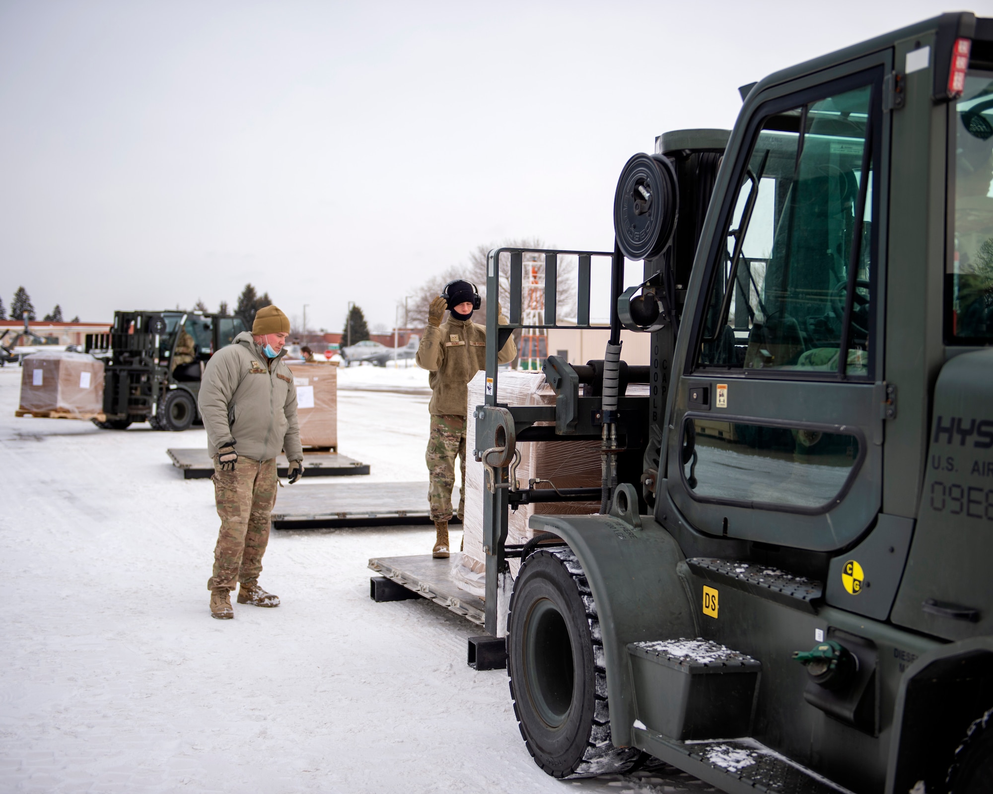 U.S. Air Force Senior Airman Lloyd Young and Staff Sgt. Jacob Mueller, Air Transportation Specialists with the 133rd Air Transportation Function, marshals a forklift during pallet buildup in St. Paul, Minn., Jan. 08, 2022.