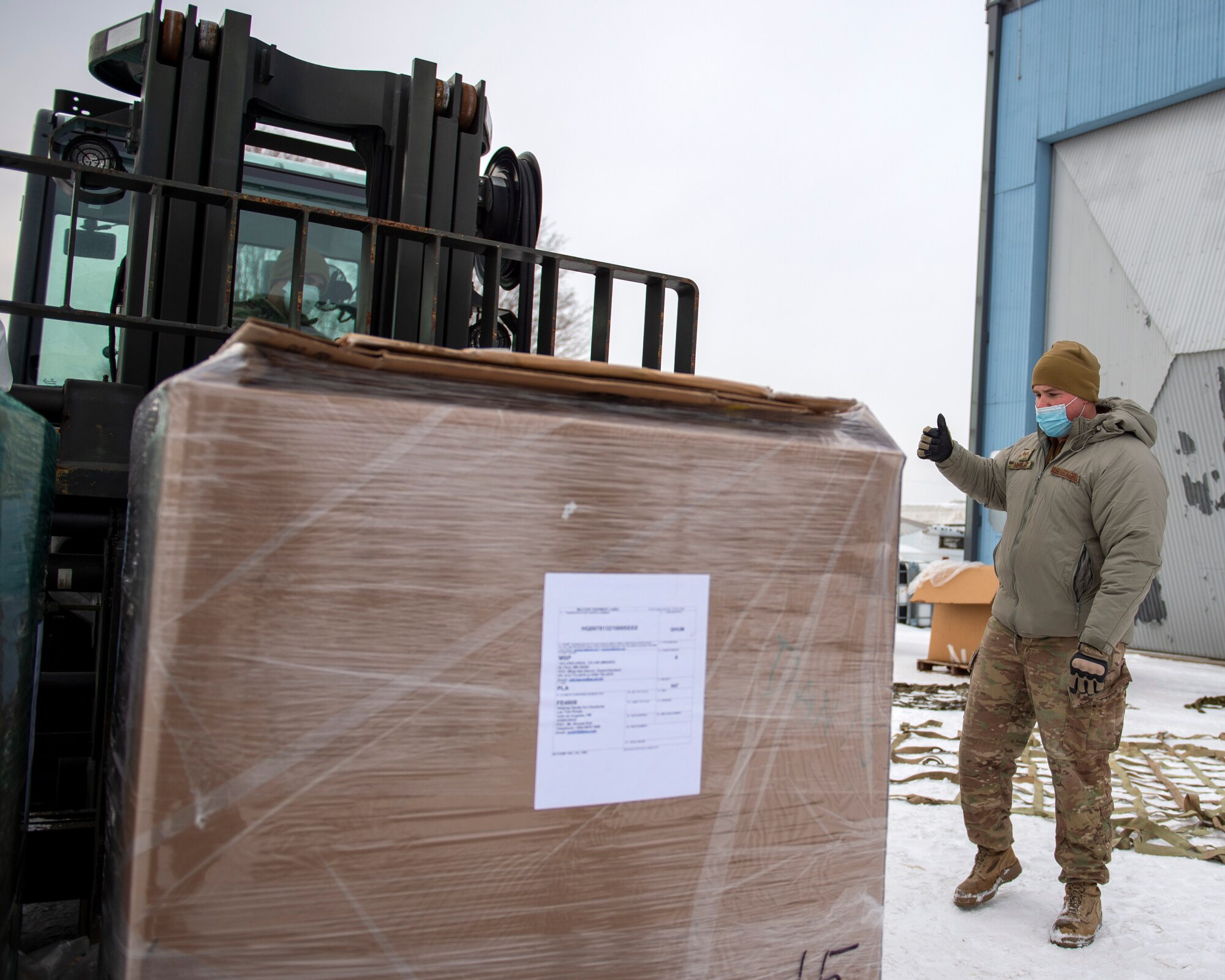 U.S. Air Force Staff Sgt. Jacob Mueller, Air Transportation Specialist with the 133rd Air Transportation Function, marshals the forklift during pallet buildup in St. Paul, Minn., Jan. 08, 2022.